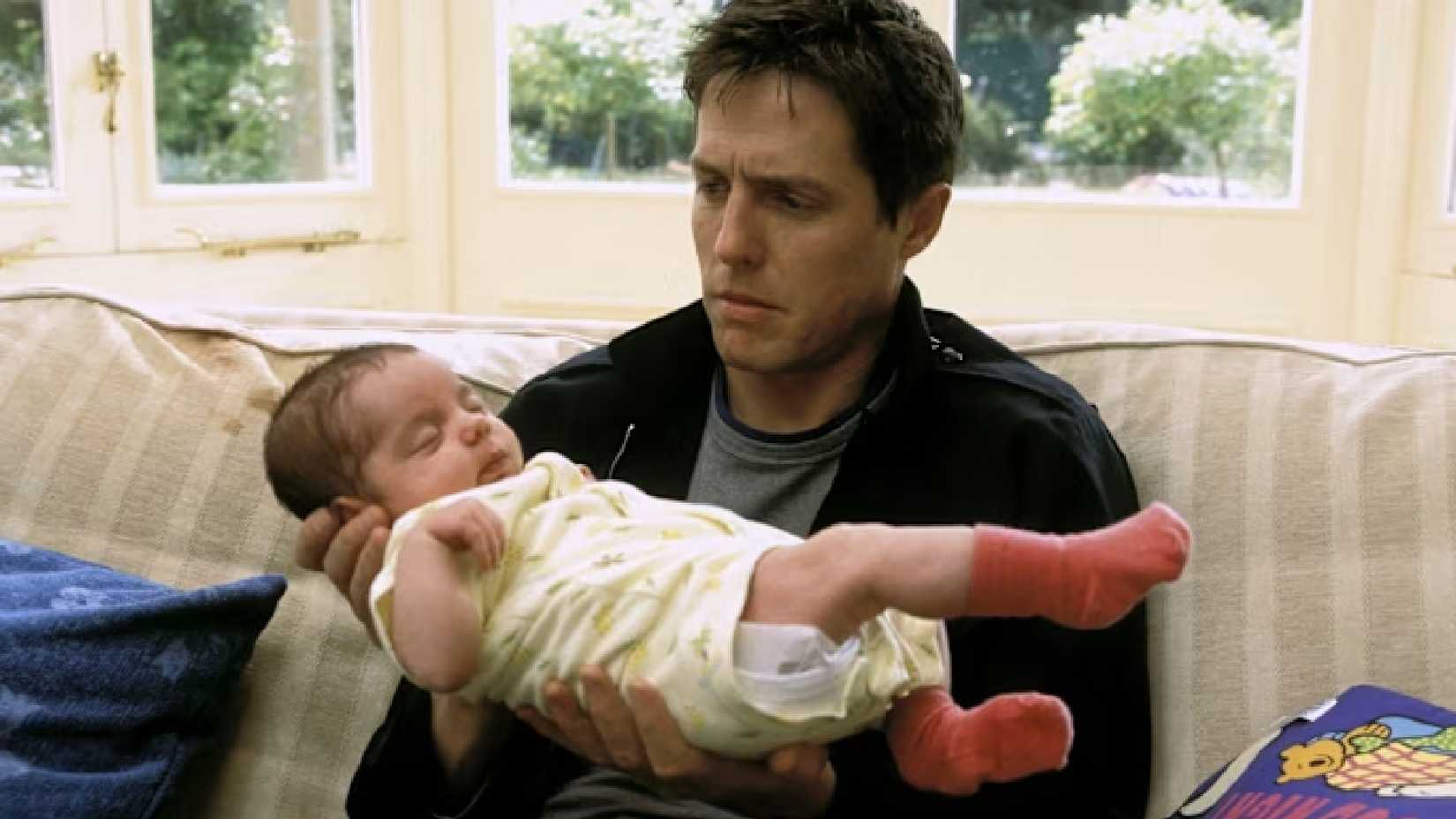 hugh grant reluctantly holding a baby in about a boy