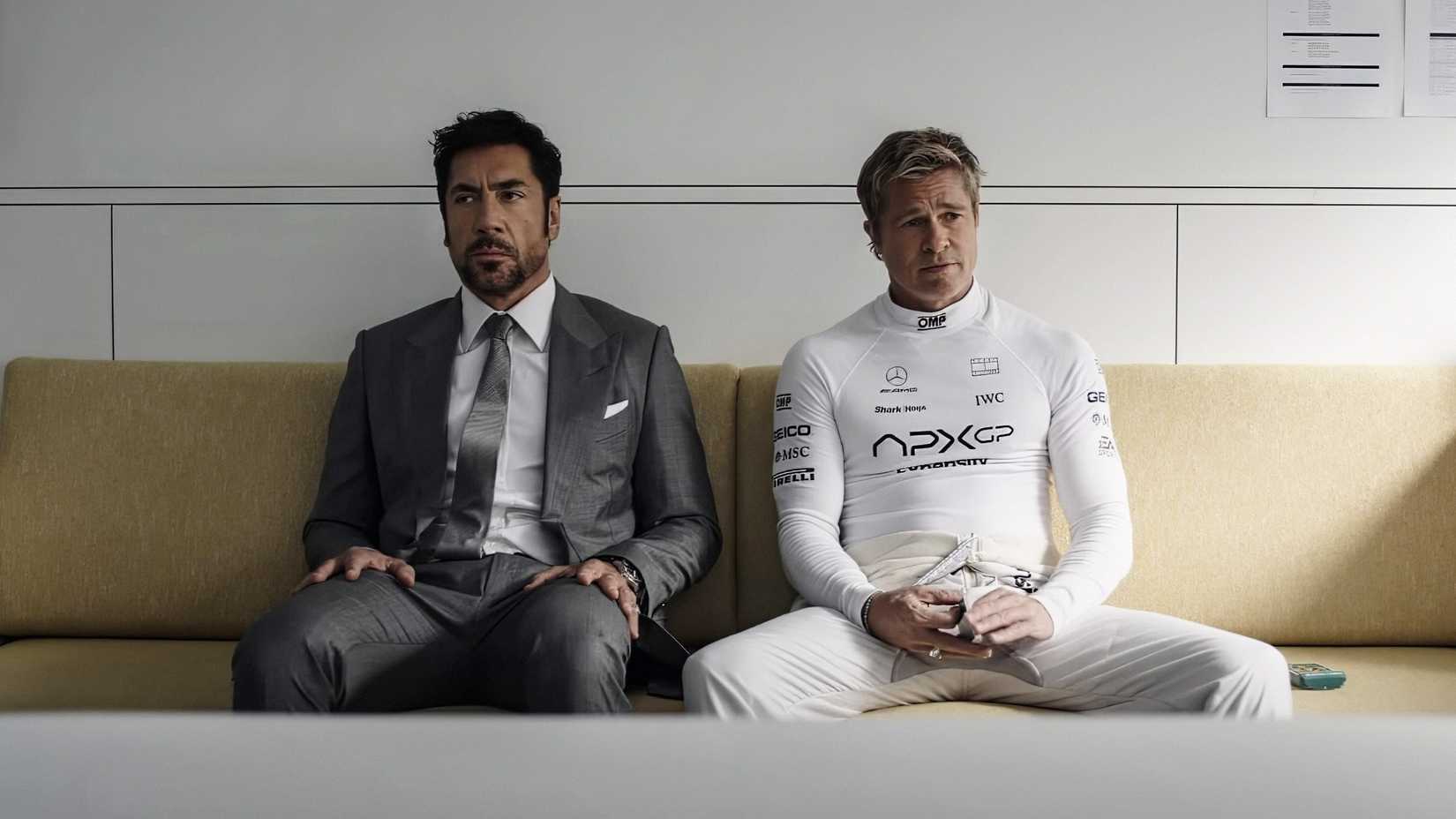 javier bardem and brad pitt sitting next to each other looking grim in f1