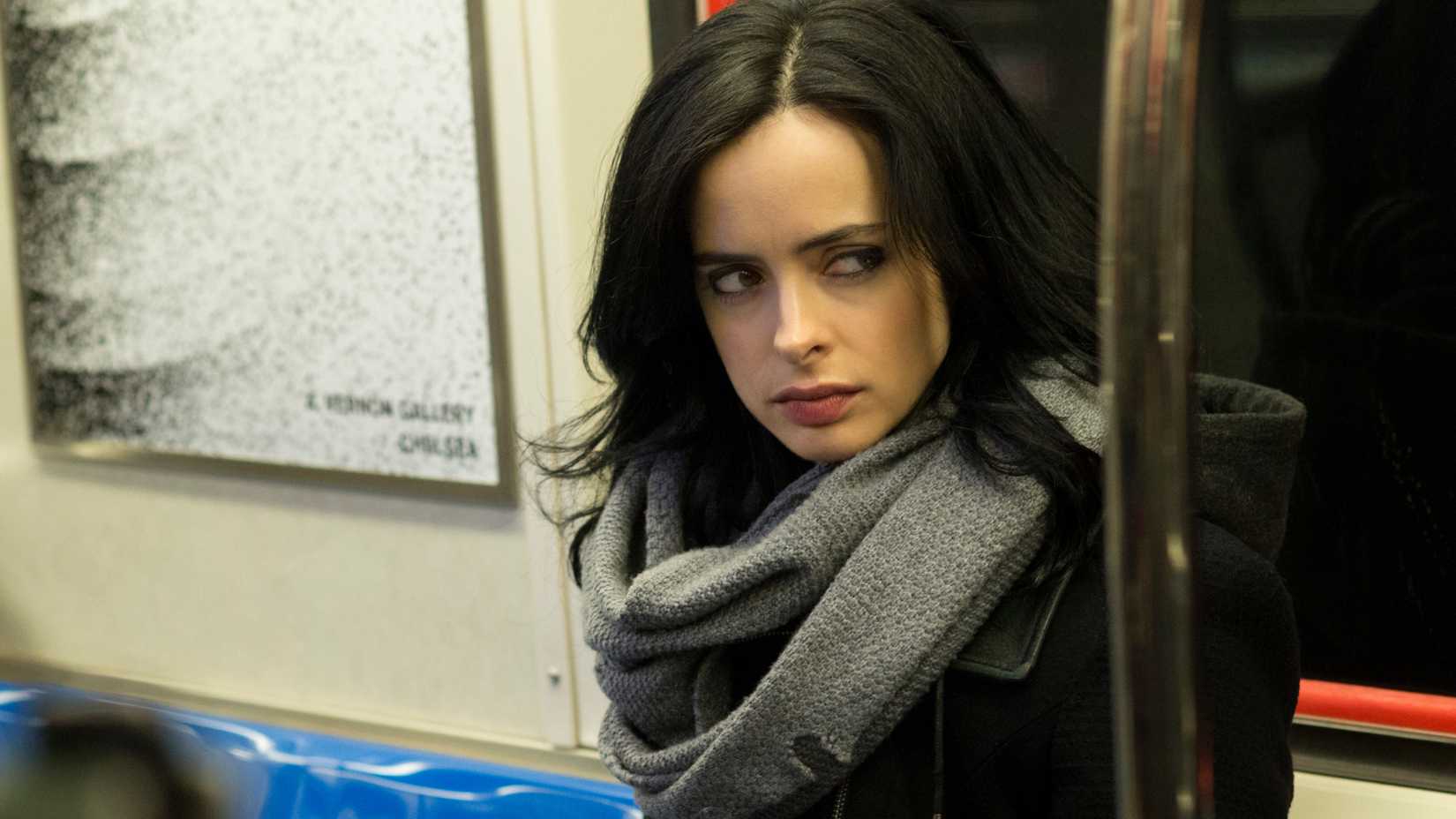 Every Marvel Netflix TV Show, Ranked From Worst To Best 3 Krysten Ritter as Jessica Jones wearing a scarf and giving side-eye while riding the train in Jessica Jones