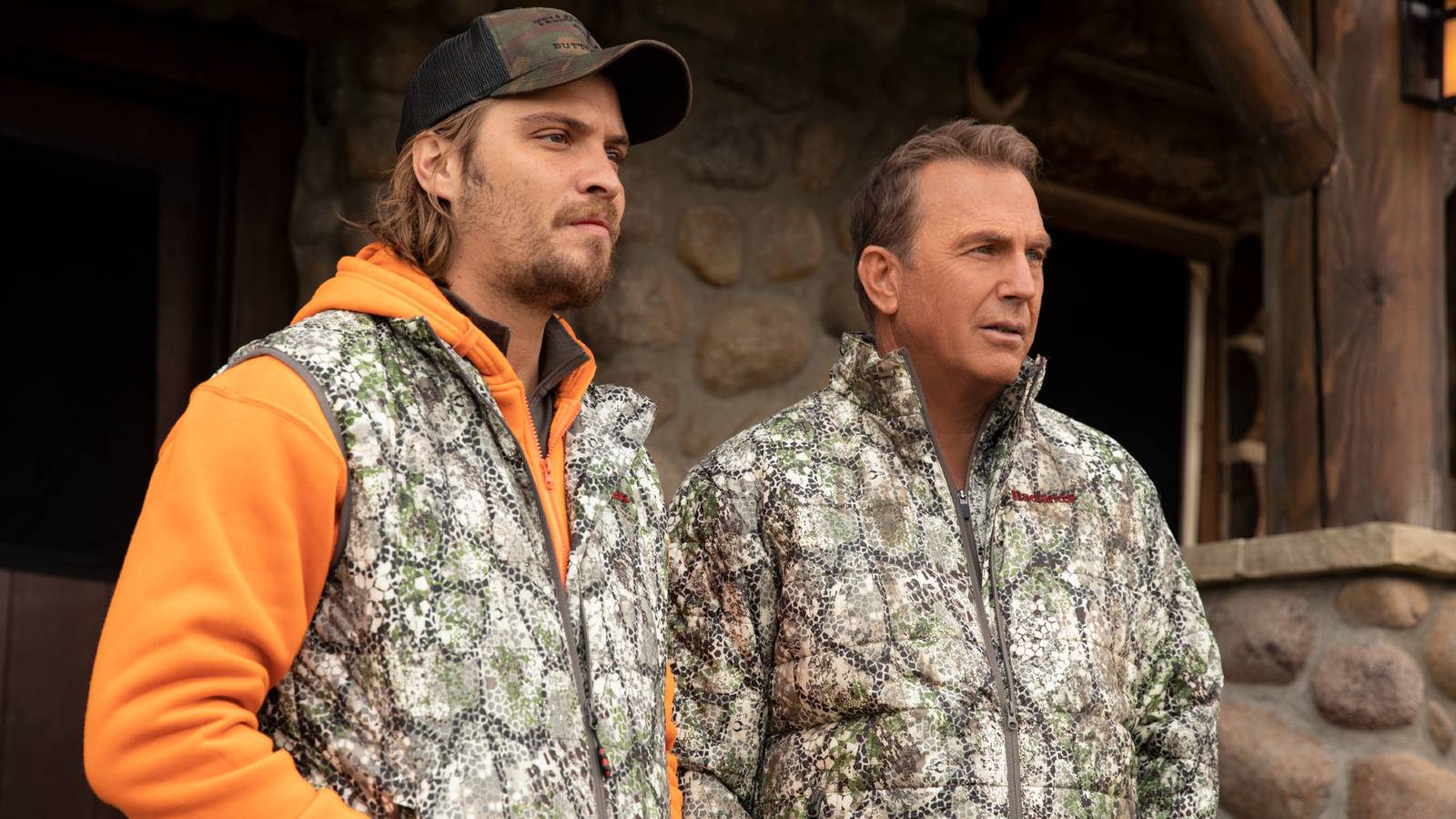 Luke Grimes and Kevin Costner as Kayce and John Dutton wearing camoflage jackets in Yellowstone