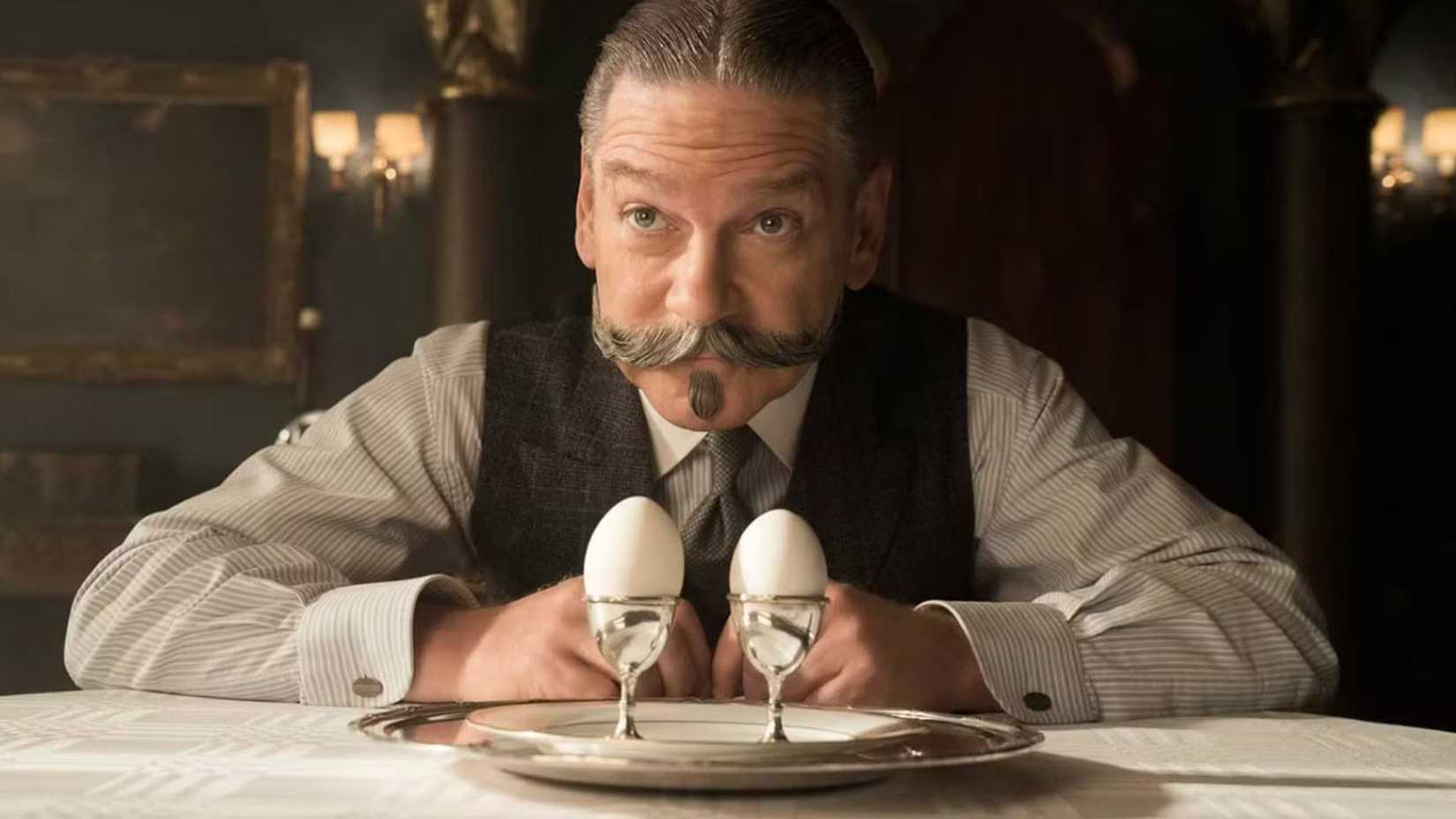 Kenneth Branagh as Hercule Poirot inspects two eggs in Murder on the Orient Express