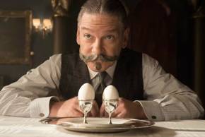 Kenneth Branagh as Hercule Poirot inspects two eggs in Murder on the Orient Express