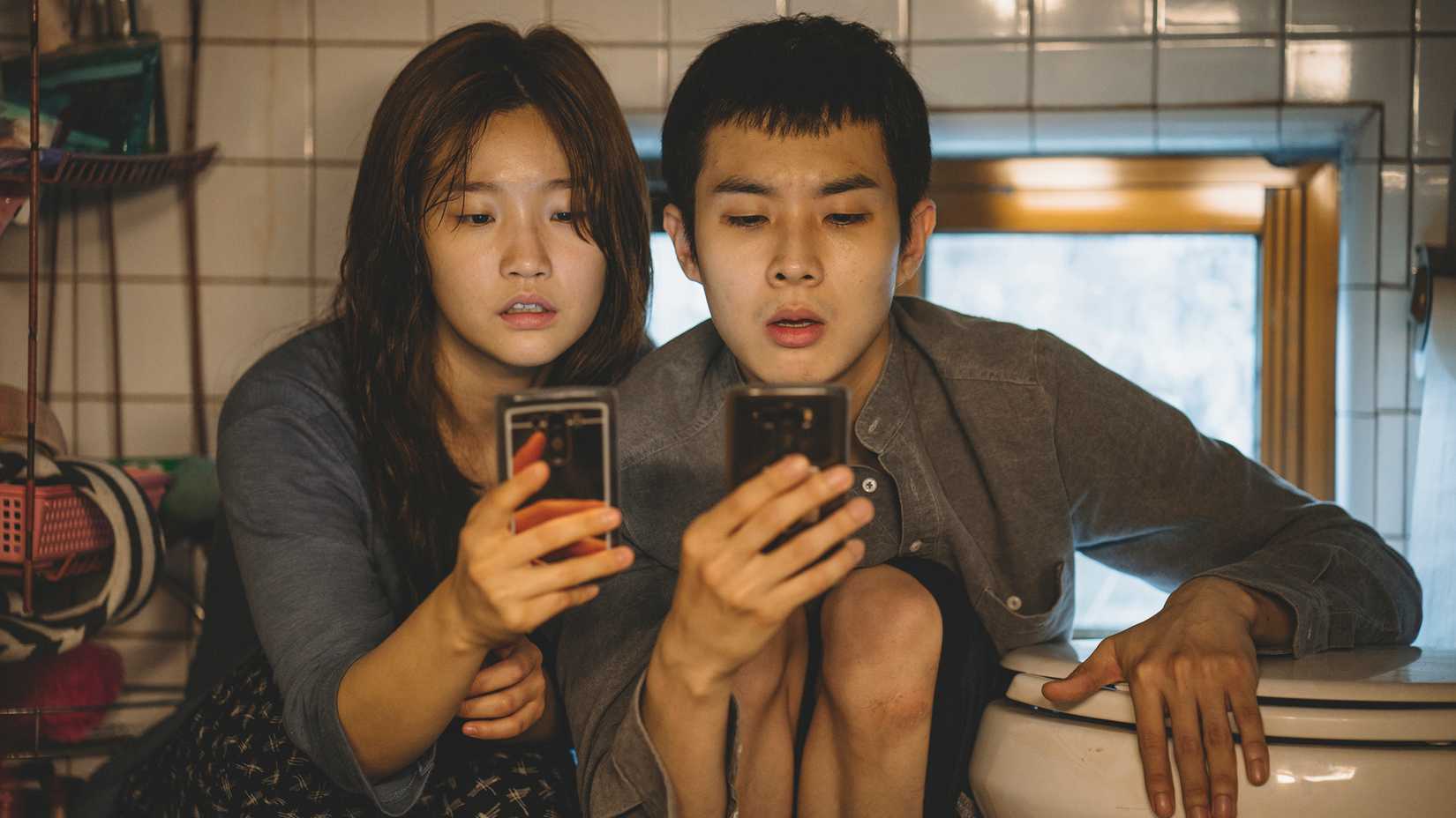 Ki-kung and Ki-woo on their phones in Parasite