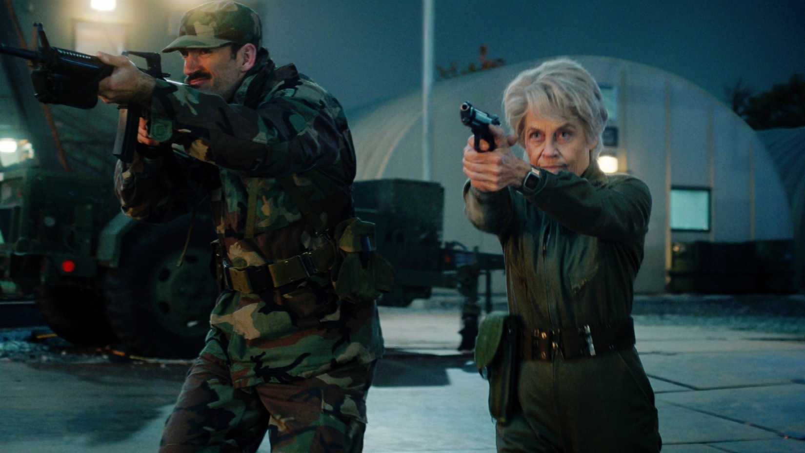 Linda Hamilton as Dr. Kay with a soldier shoots a gun in Stranger Things