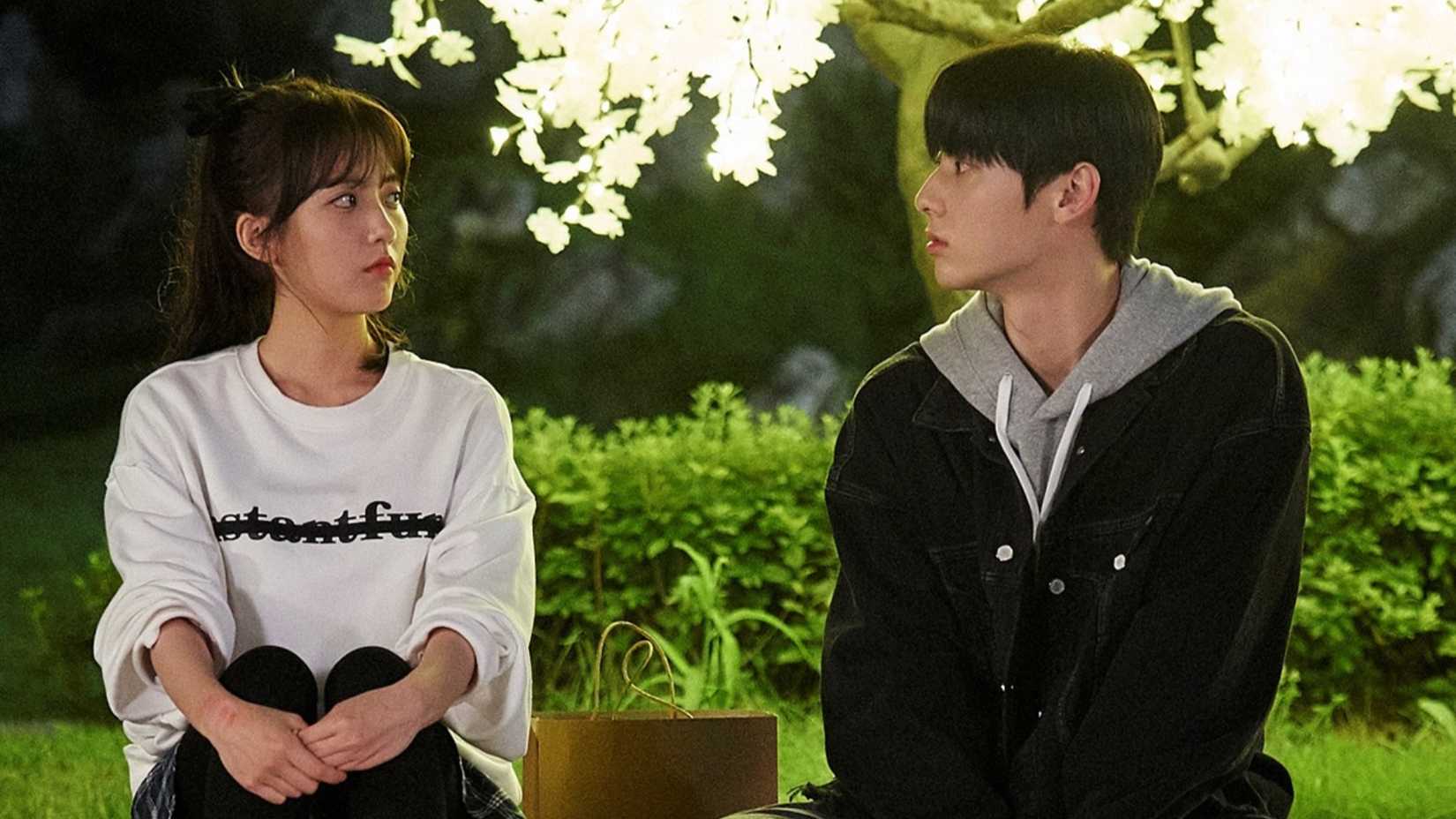 A young couple sit in a park at night in the K-drama Live On.