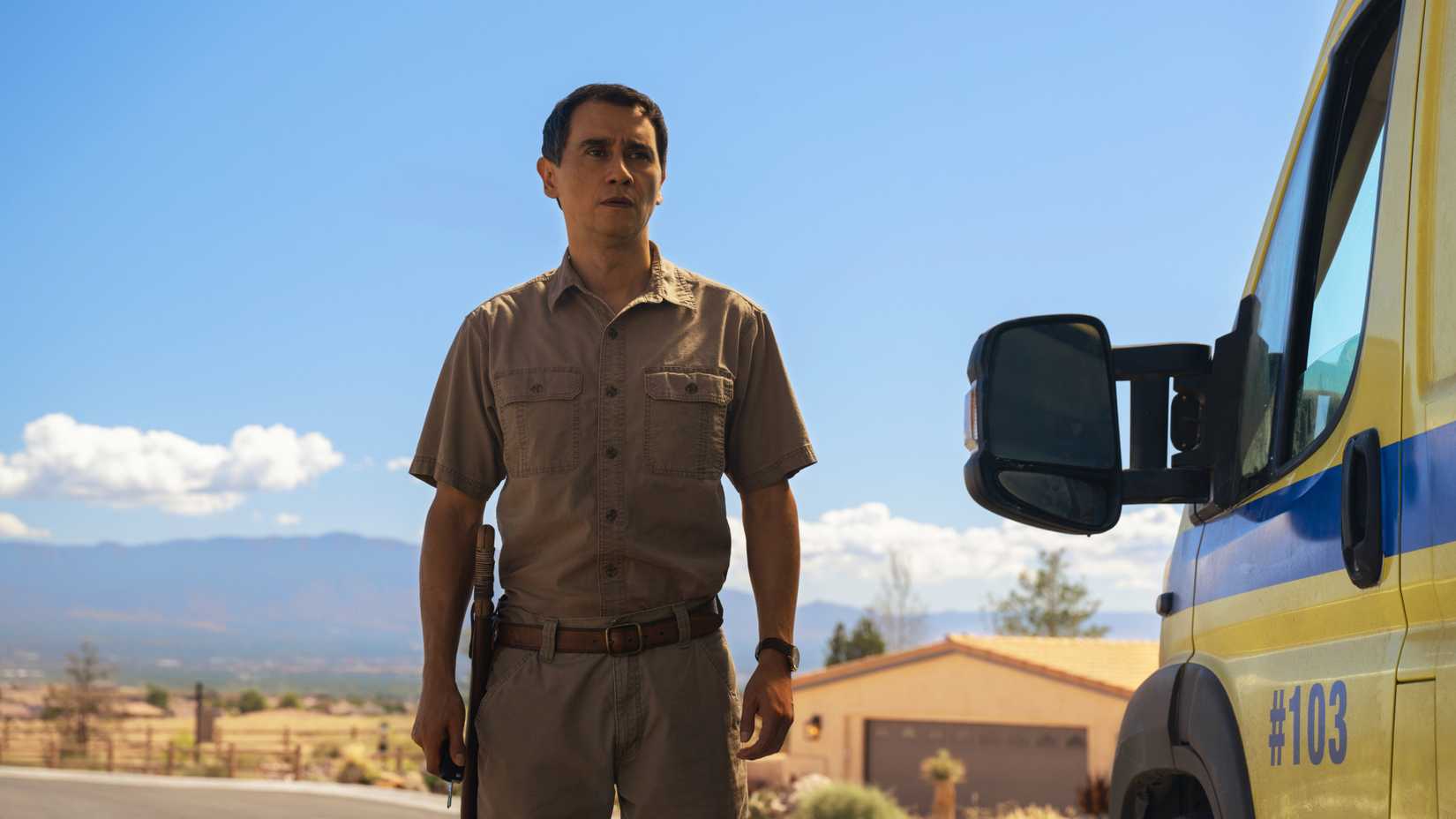 Manousos arrives outside of Carols house and stands next to his ambulance in Pluribus season 1 finale