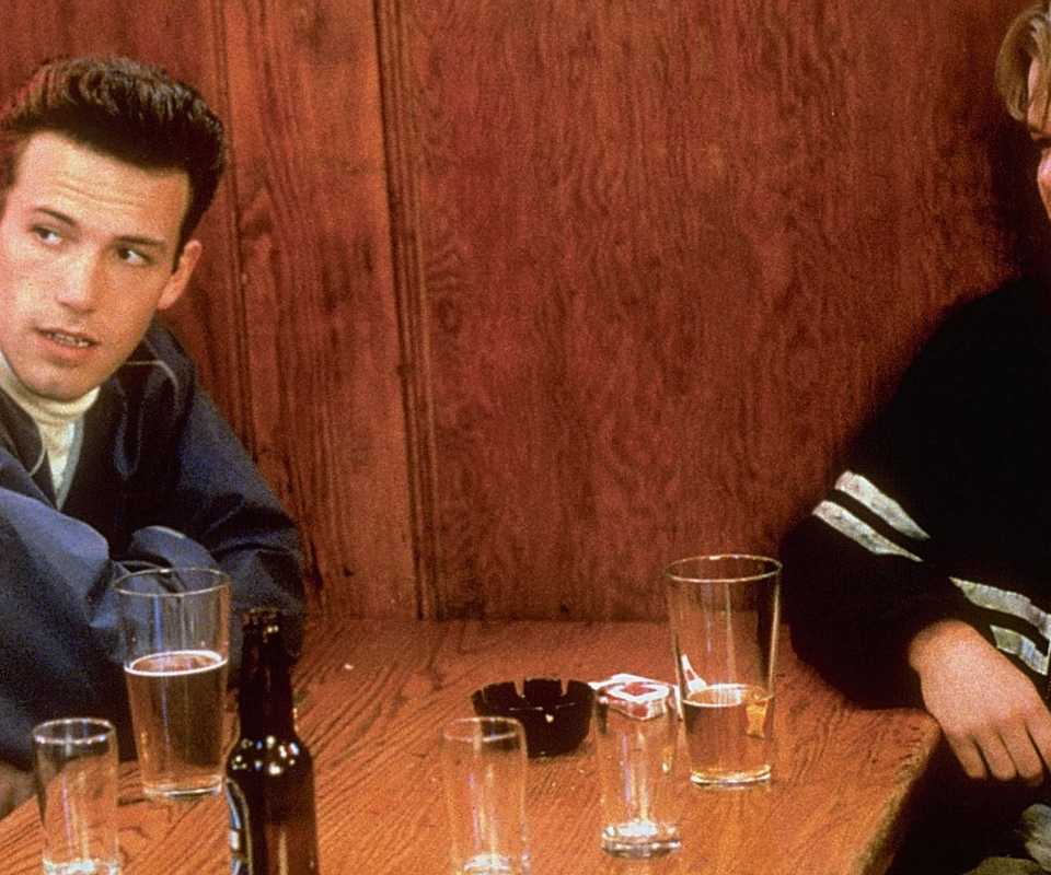 Matt Damon as Will Hunting and Ben Affleck as Chuckie sit together at the bar.