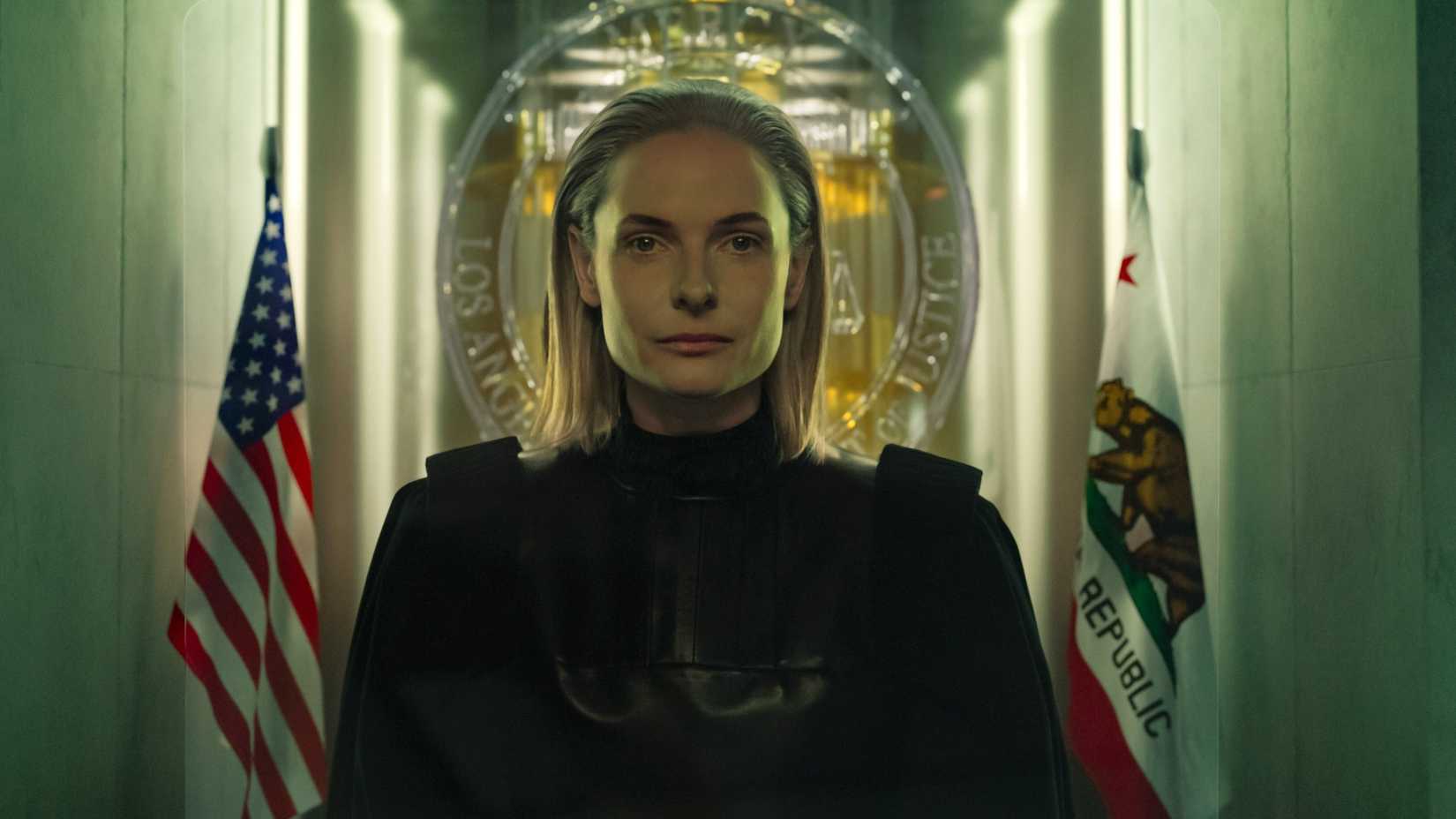 Judge Maddox (Rebecca Ferguson) looks stoic as she sits in front of Mercy's two flags.