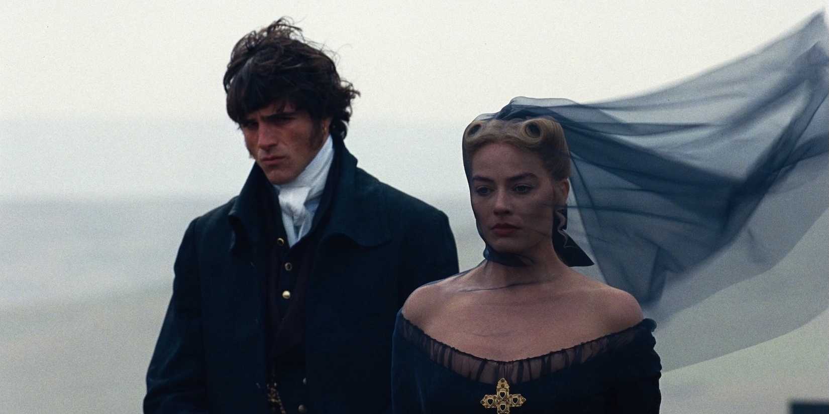 Jacob Elordi wearing a suit and Margot Robbie wearing a black dress in Wuthering Heights.