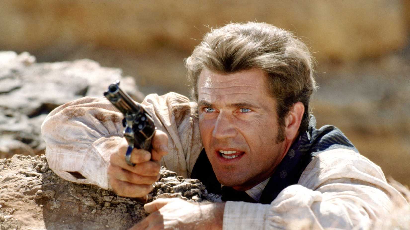 Mel Gibson as Maverick hanging off a cliff in Maverick (1994)