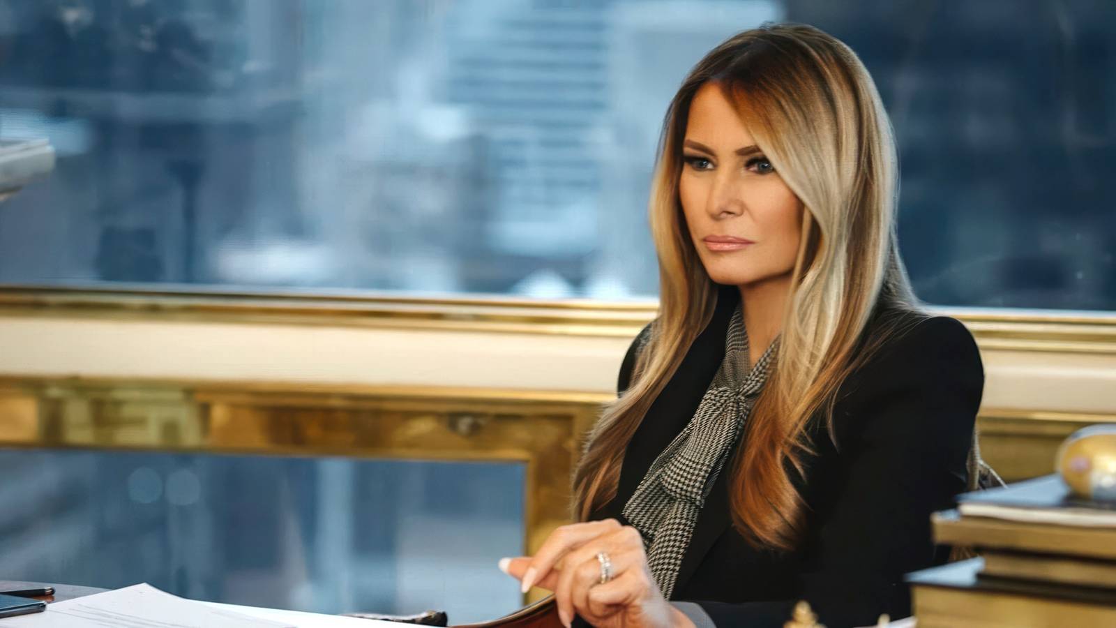 Melania seated staring into the middle distance in Melania