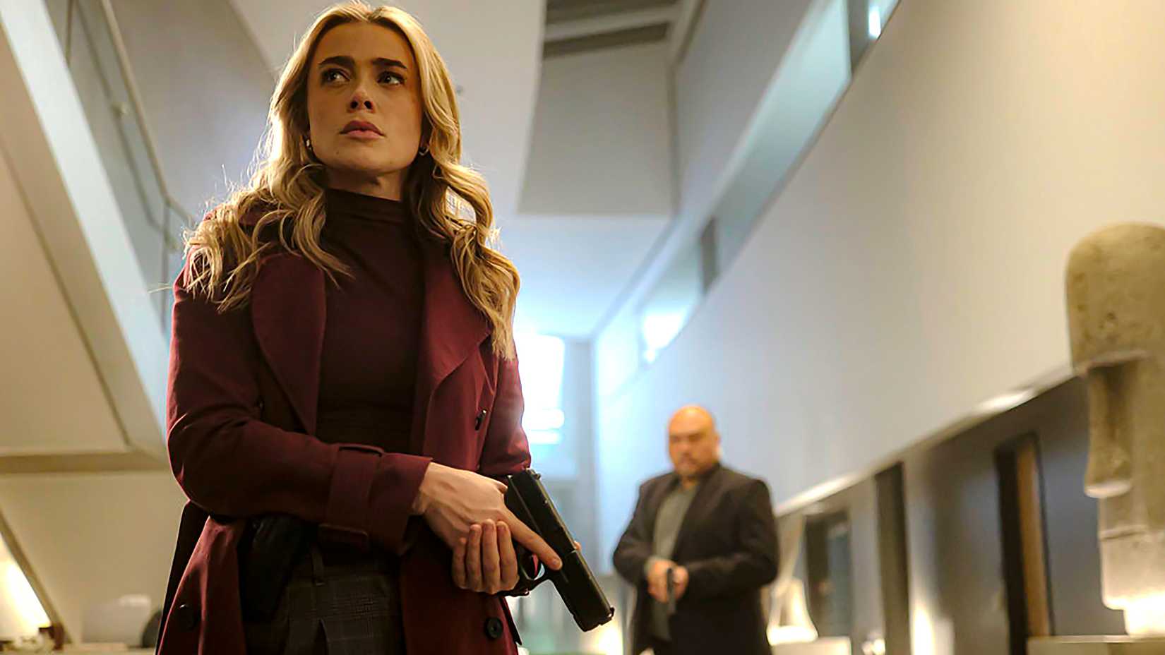 Melissa Roxburgh's Bex holding a pistol and looking cautious in The Hunting Party season 1