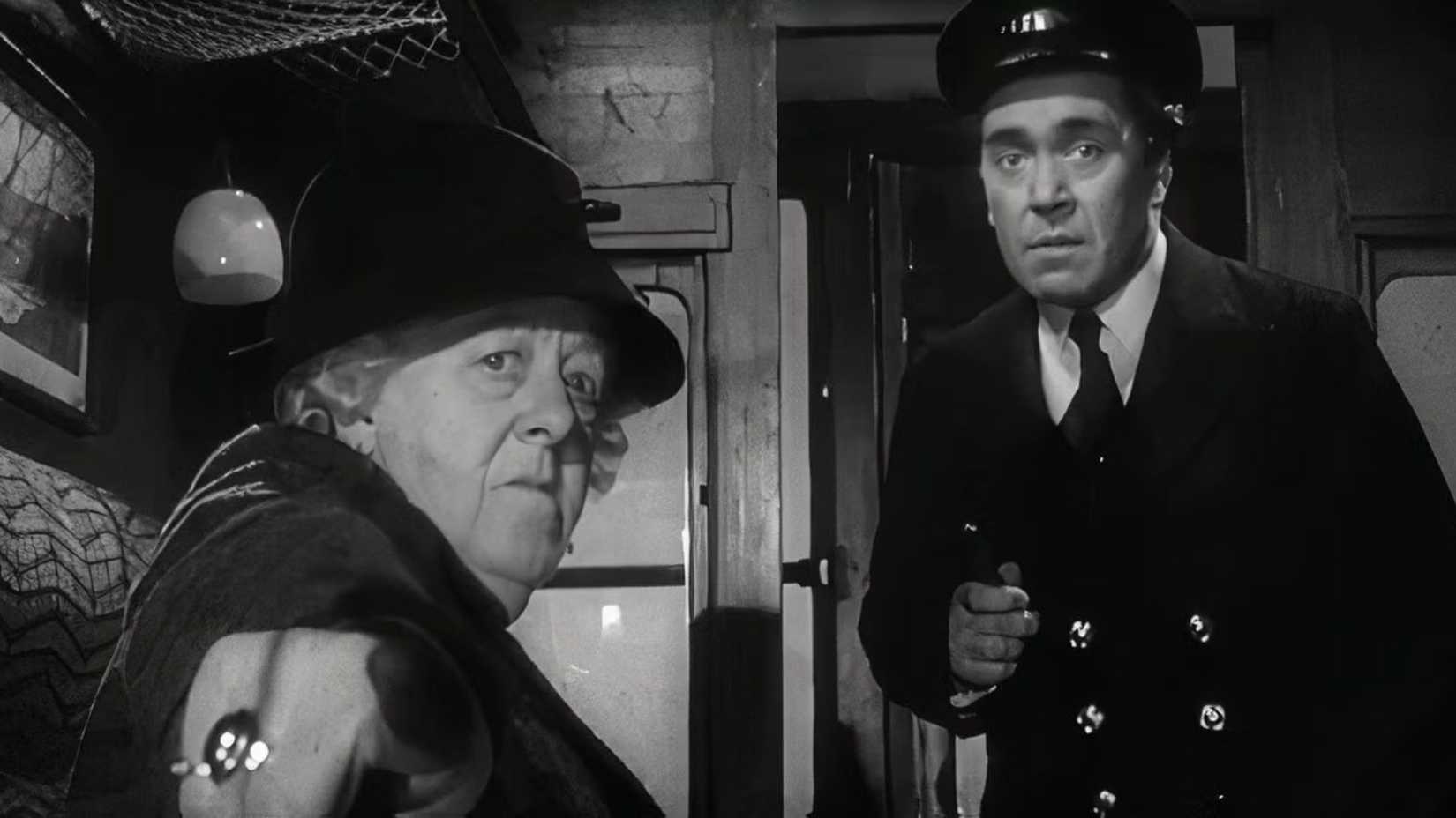 Miss Marple pointing at something off-screen to a Train Conductor while riding a train in Murder She Said