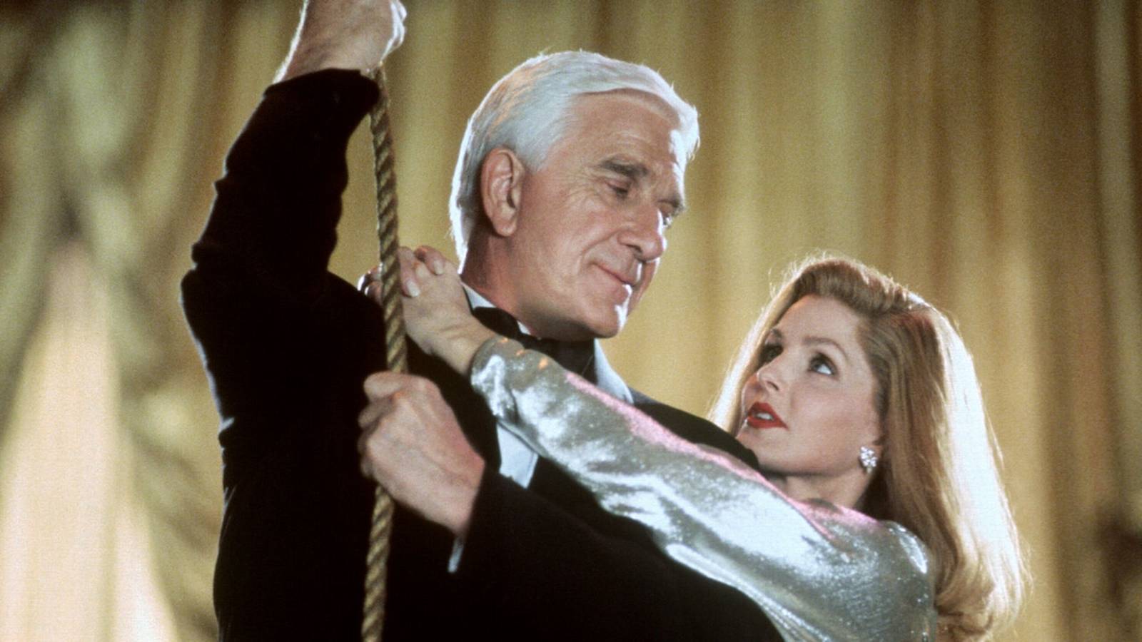 Leslie Nielsen and Priscilla Presley prepare to swing on a rope in Naked Gun 33 1/3