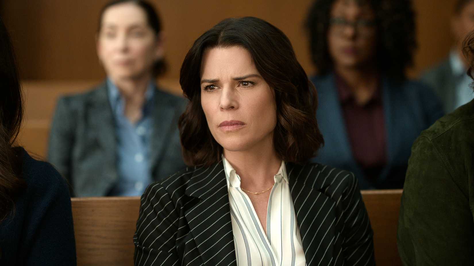 Neve Campbell as Maggie McPherson sitting in court in The Lincoln Lawyer season 4