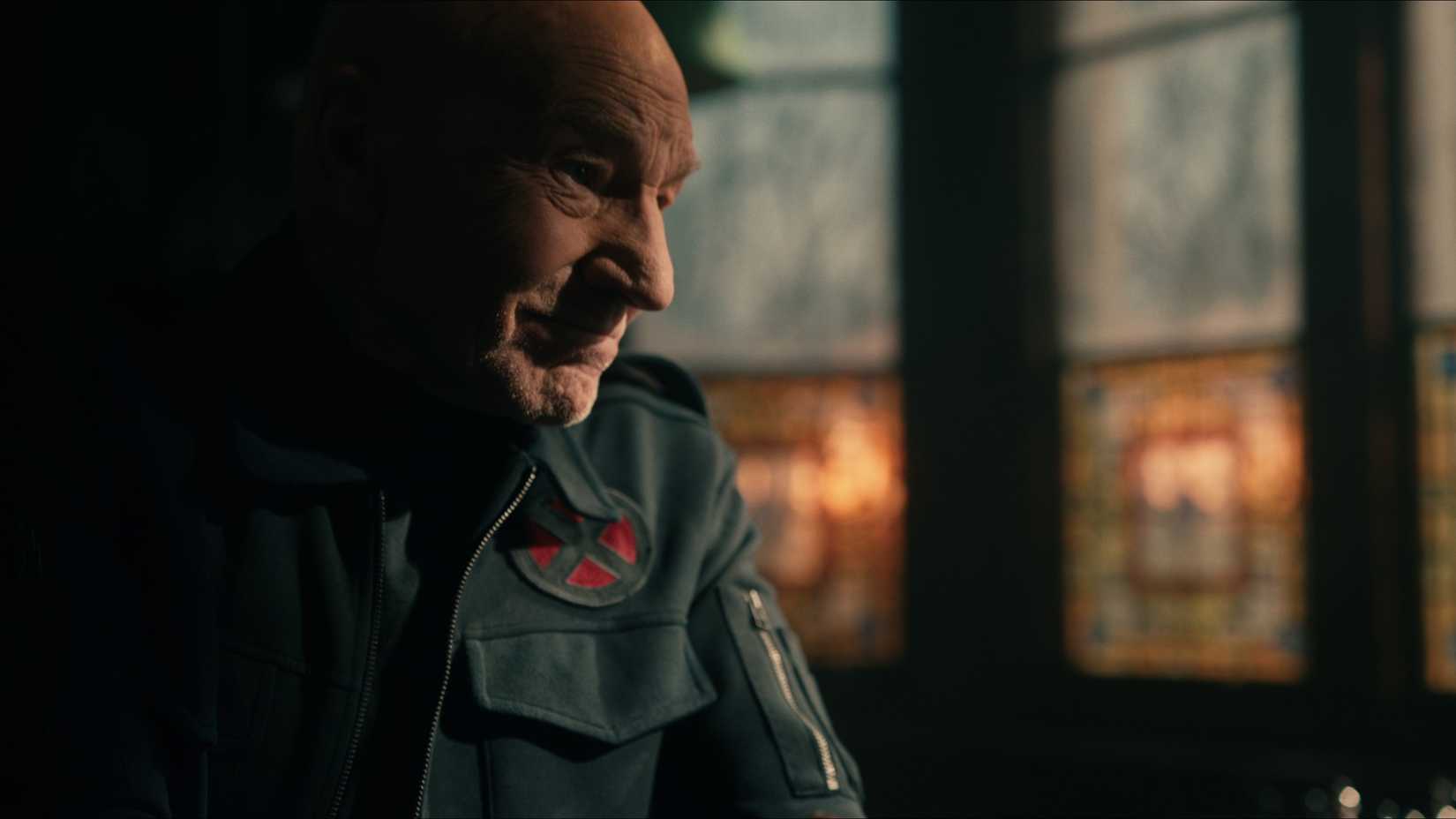 Patrick Stewart sebagai Profesor X di depan jendela kaca patri dalam trailer Avengers Doomsday.