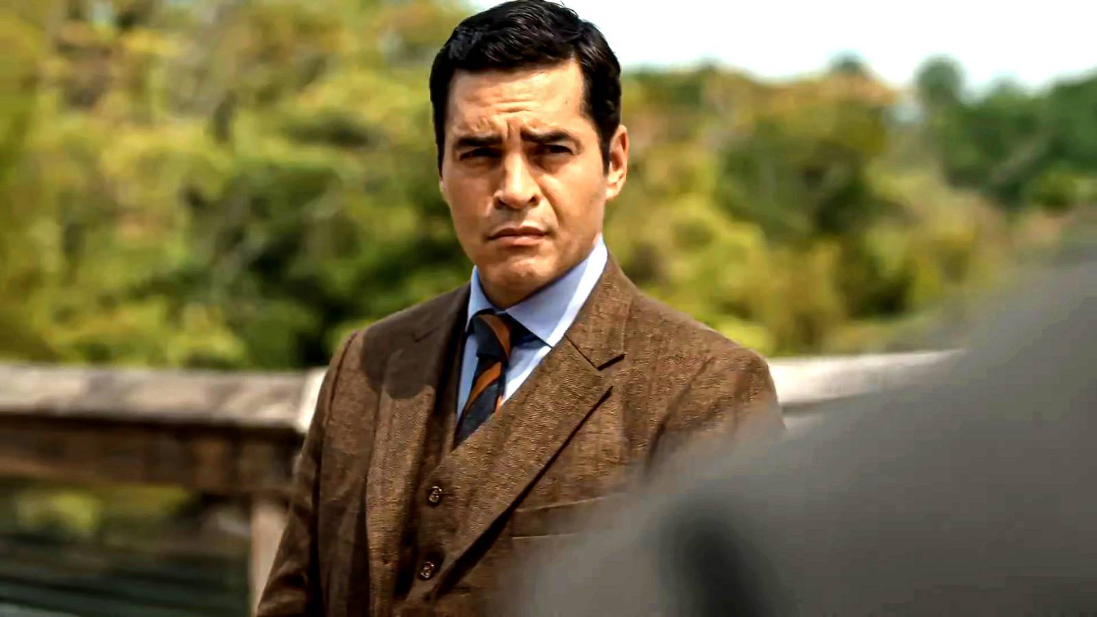 Ramón Rodriguez's Will looking suspiciously at someone in a sunny setting in Will Trent season 4