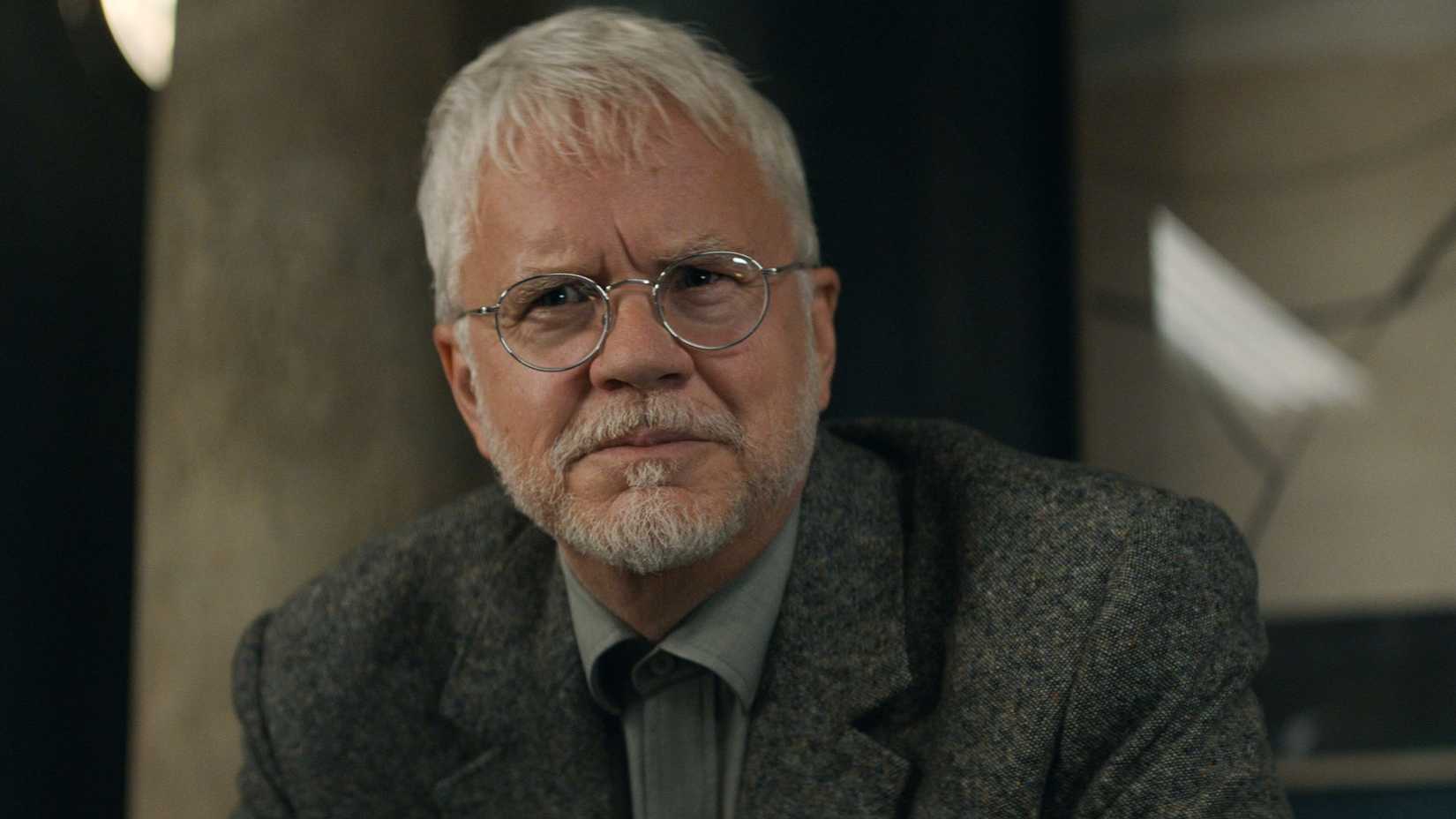 Tim Robbins as Bernard Holland with a small smile in Silo.