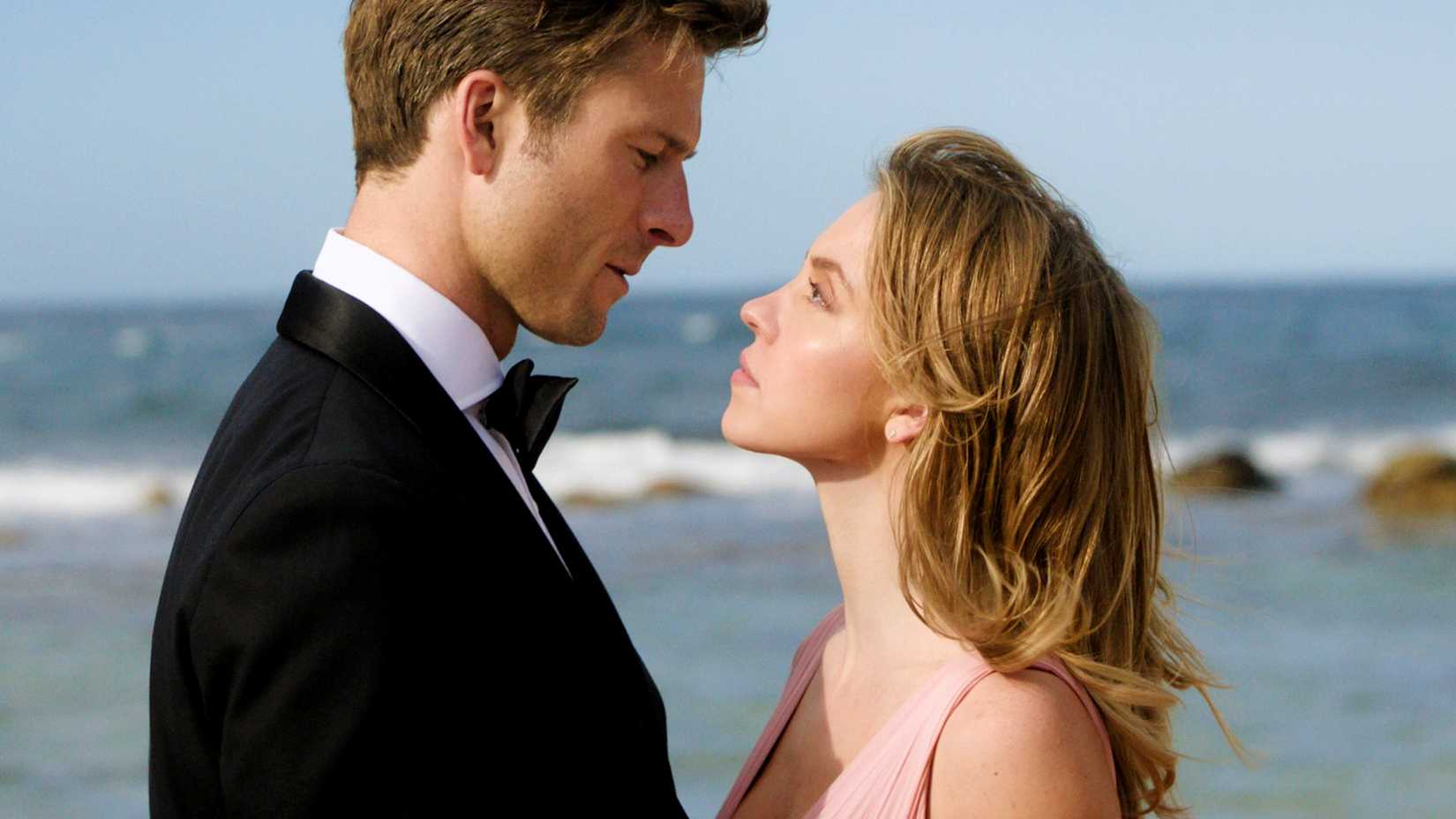 Sydney Sweeney and Glen Powell gazing at one another on the beach in Anyone But You