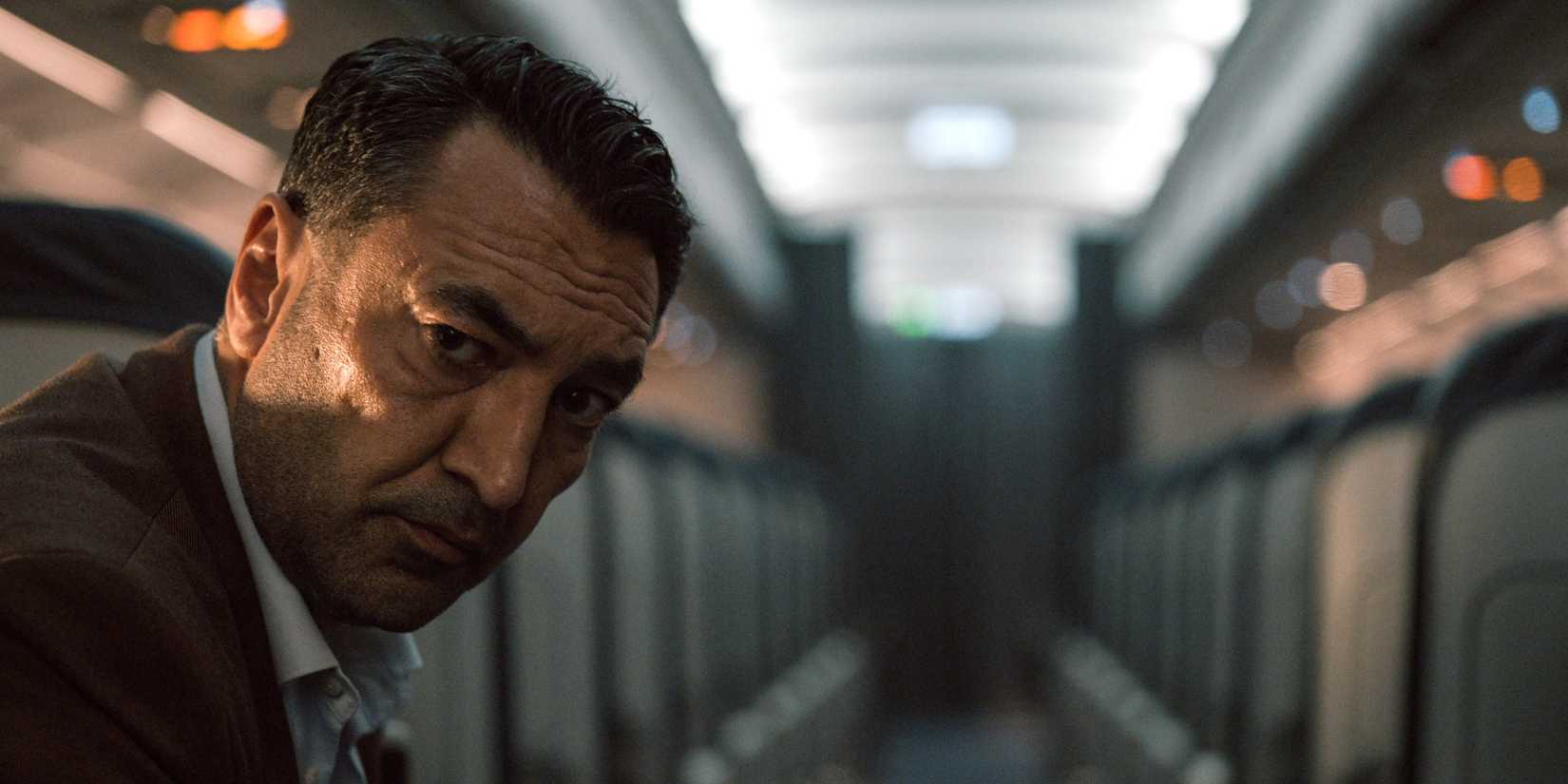 Mehmet Kurtuluş as Ayaz Kobanbay looking down a plane hallway in Into the Night.