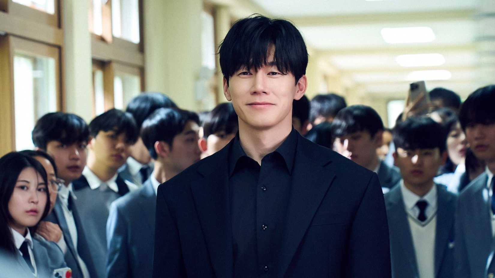 Ein Mann in einem schwarzen Anzug in einem überfüllten Schulflur im koreanischen Drama "Teach You a Lesson".
