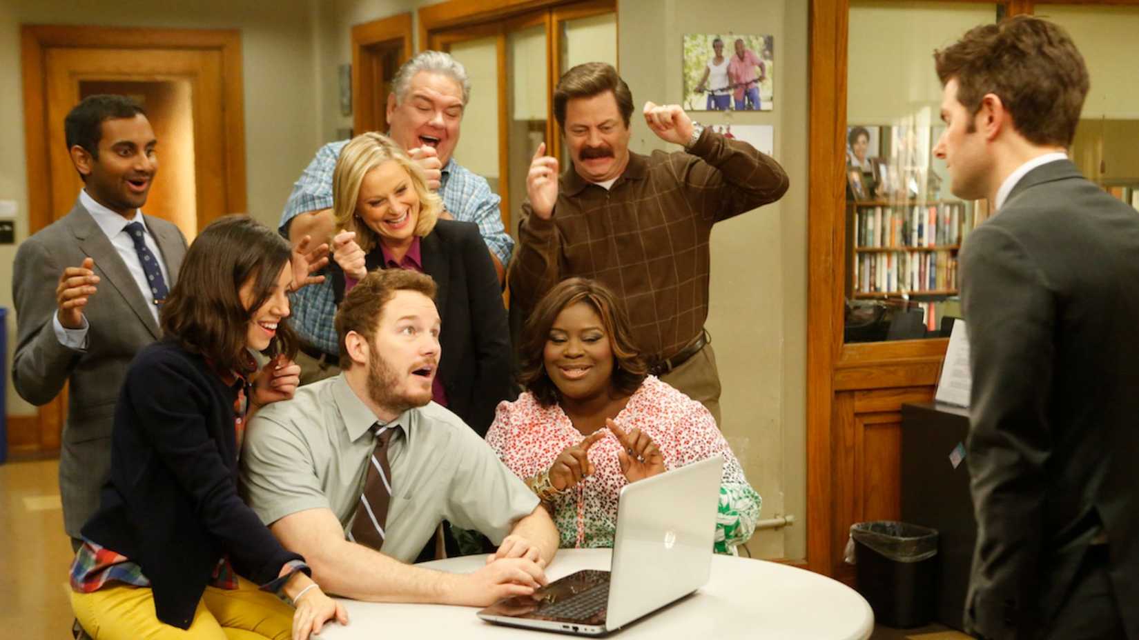 O elenco de Parks and Rec comemorando em frente ao computador