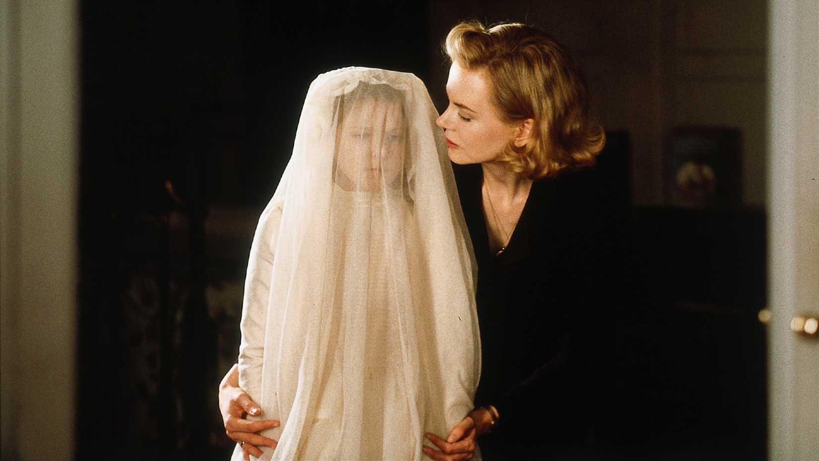 Nicole Kidman stands with a young child in a veil in The Others