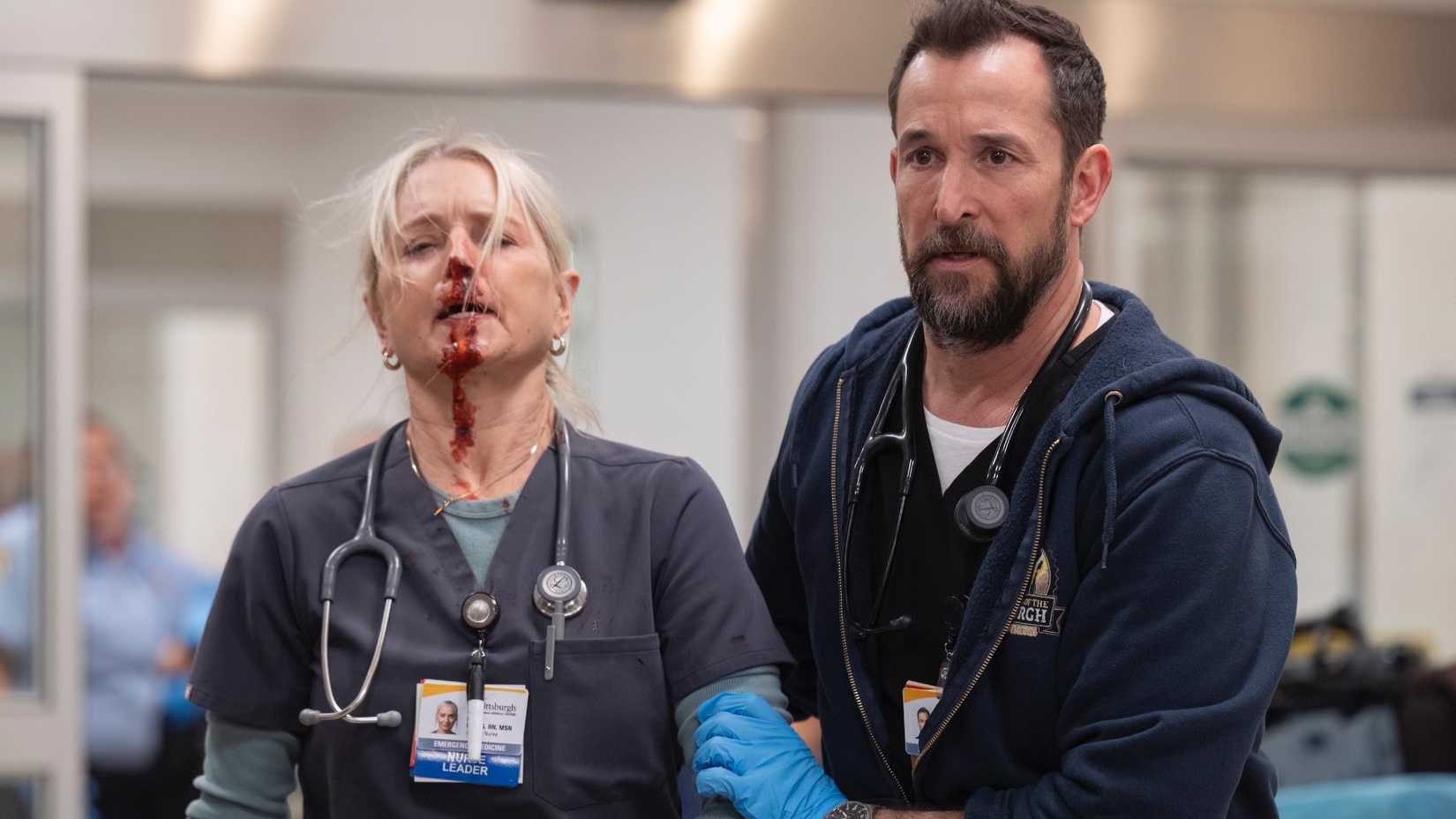 Michael "Robby" Robinavitch (Noah Wyle) walking with Dana Evans (Katherine LaNasa) who has a bloody nose in The Pitt season 1.