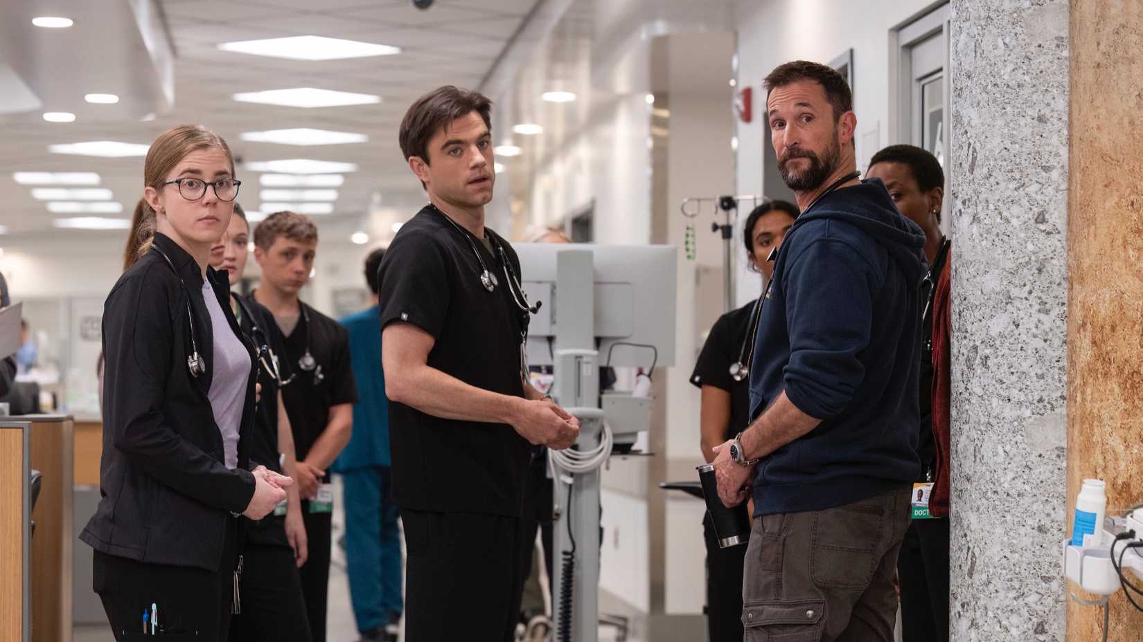 A group of doctors standing in an emergency room in The Pitt season 1.