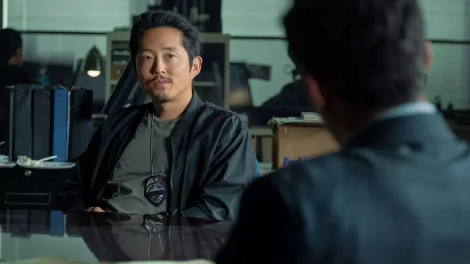 Steven Yeun looks apprehensive while talking to his boss in The Rip