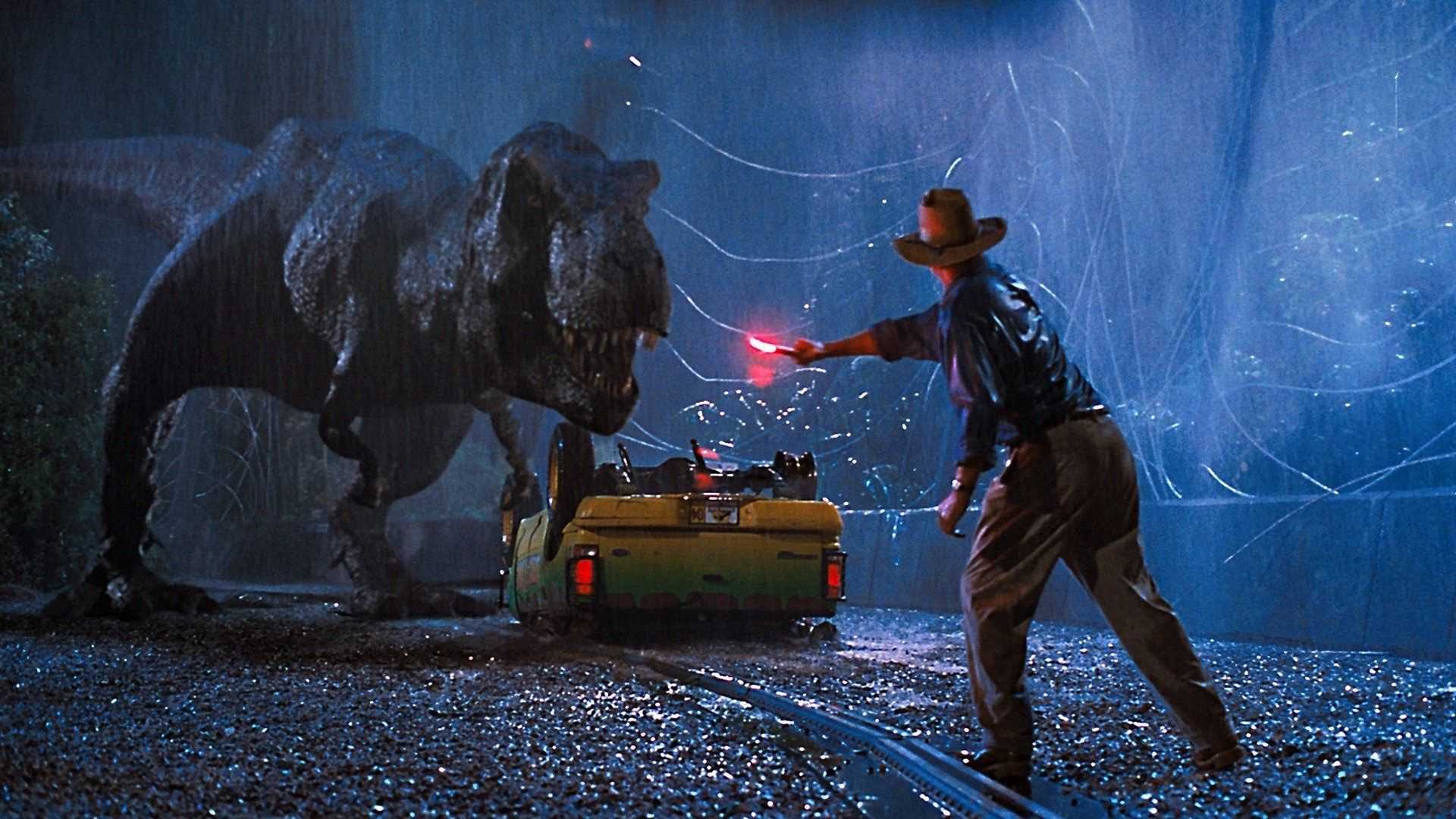 The T-Rex in Jurassic Park attacks the car while Alan Grant (Sam Neill) holds up a flare