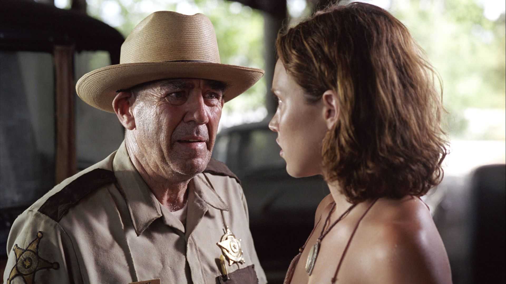 R. Lee Ermey as Sheriff Hoyt looking angry with Erica Leerhsen as Pepper in The Texas Chainsaw Massacre.