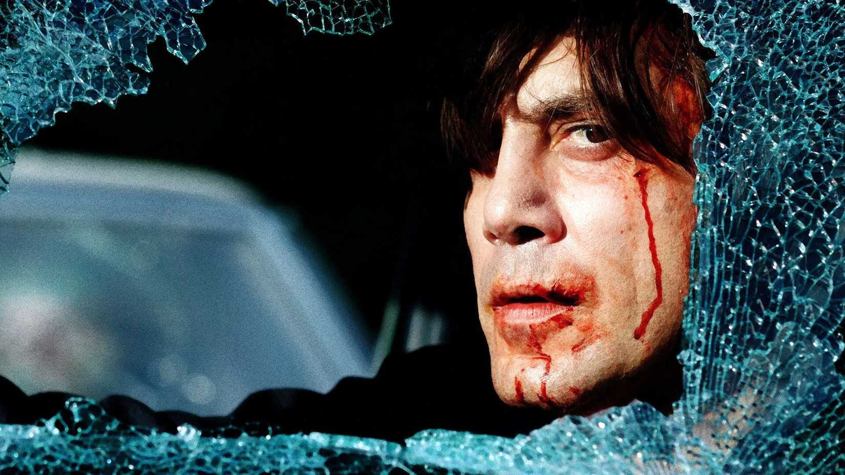 10 Thriller Movies That Are Amazing From Start to Finish 6 The wounded Anton Chigurh looking through a broken windon in No Country for Old Men