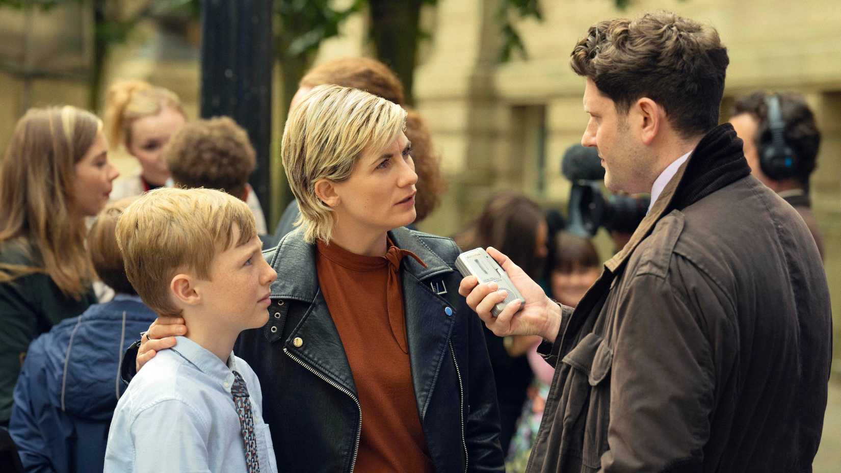 Toxic Town still featuring Jodie Whittaker as Susan McIntyre talking to a reporter with her son.