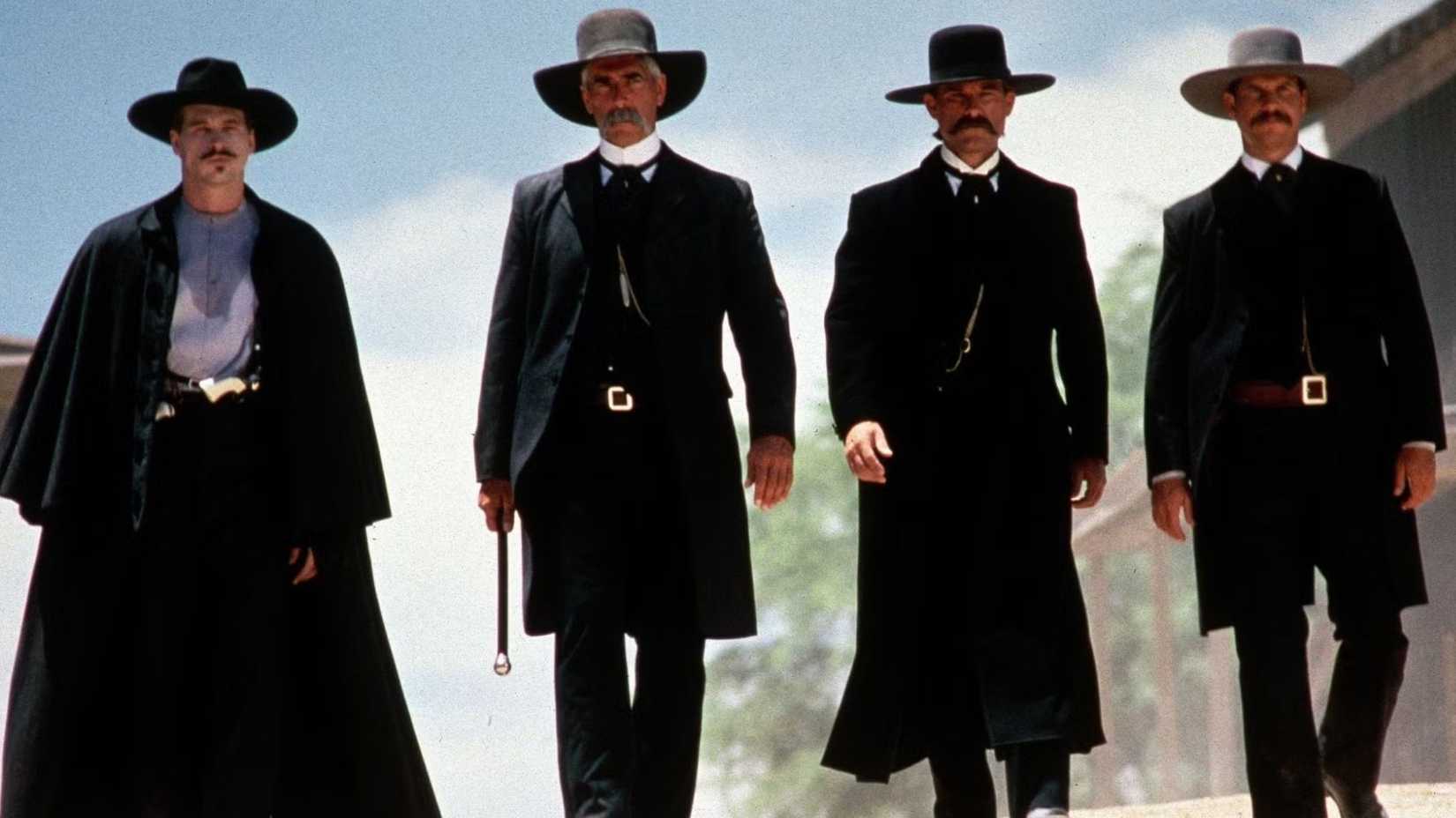 Val Kilmer as Doc Holliday, Sam Elliott as Virgil Earp, Kurt Russell as Wyatt Earp, and Bill Paxton as Morgan Earp as they walk through town in Tombstone