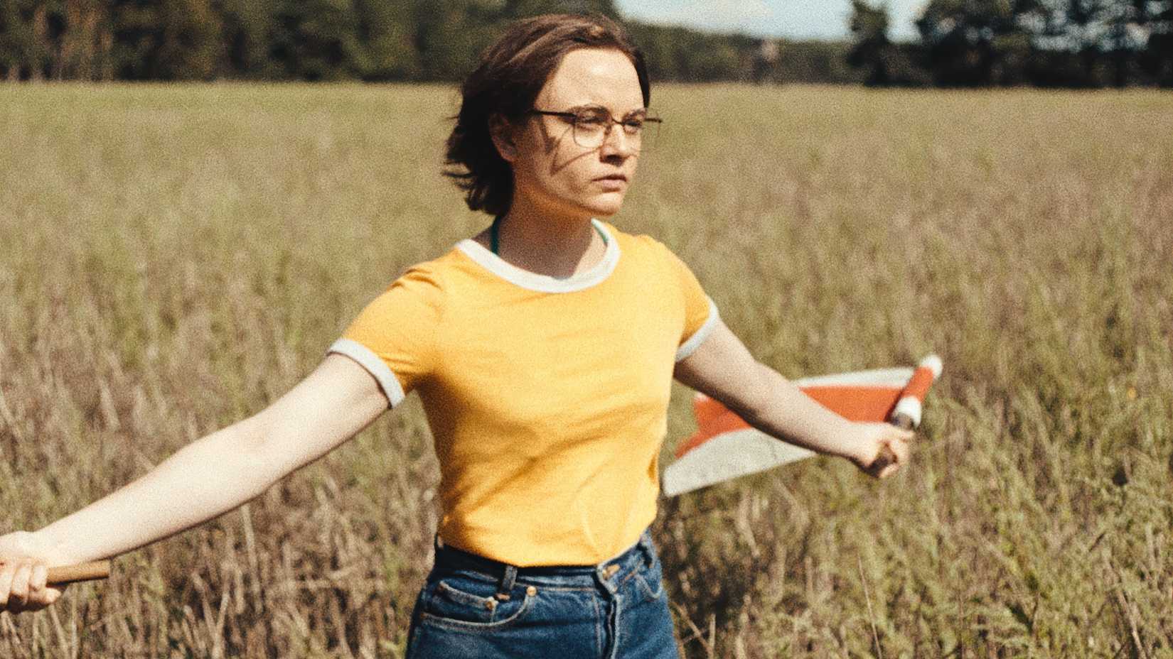 Eine junge Frau auf einem Feld mit Fahnen in Sound of Falling