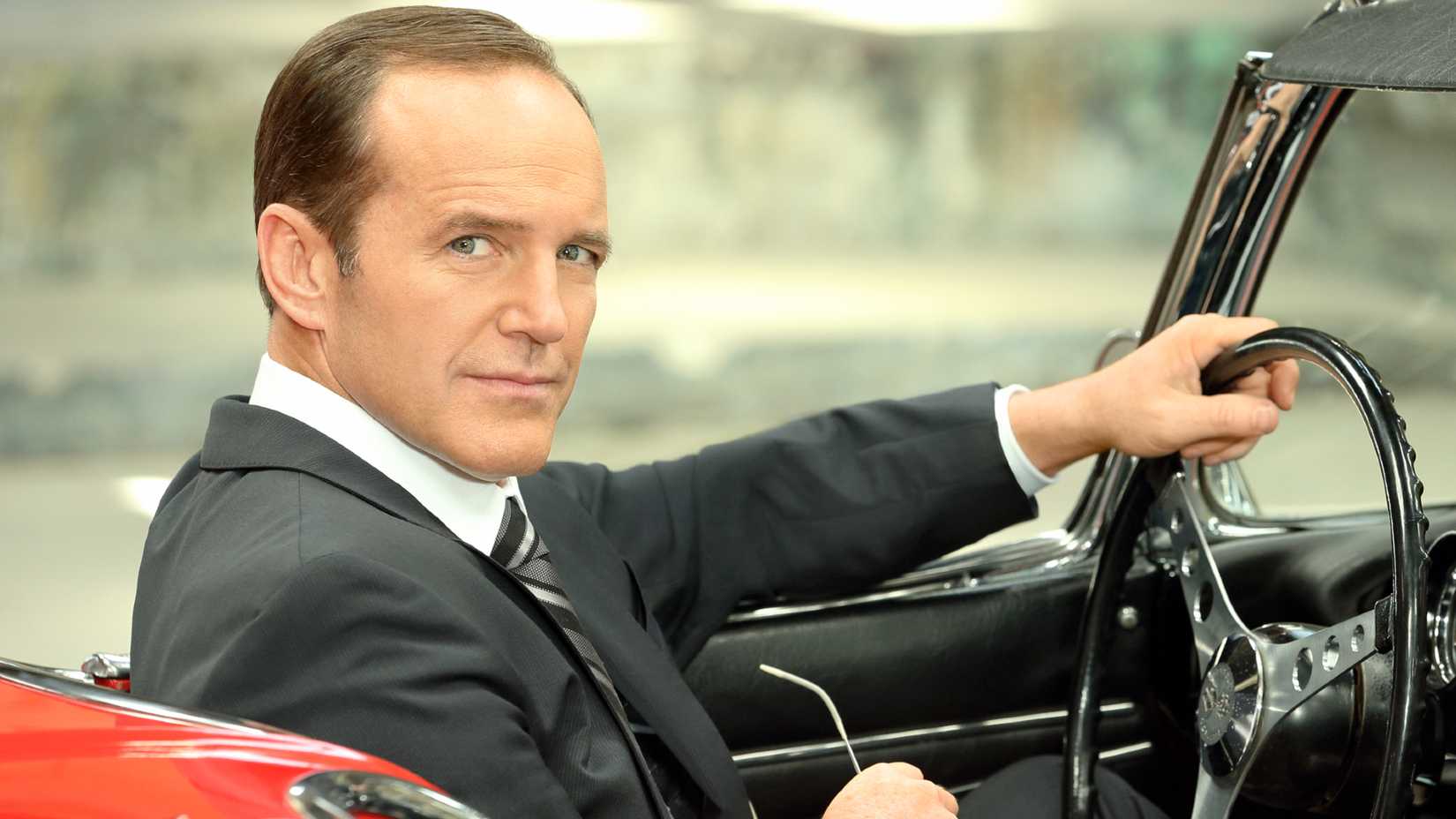 Agent Coulson sitting in a red car in Agents of SHIELD