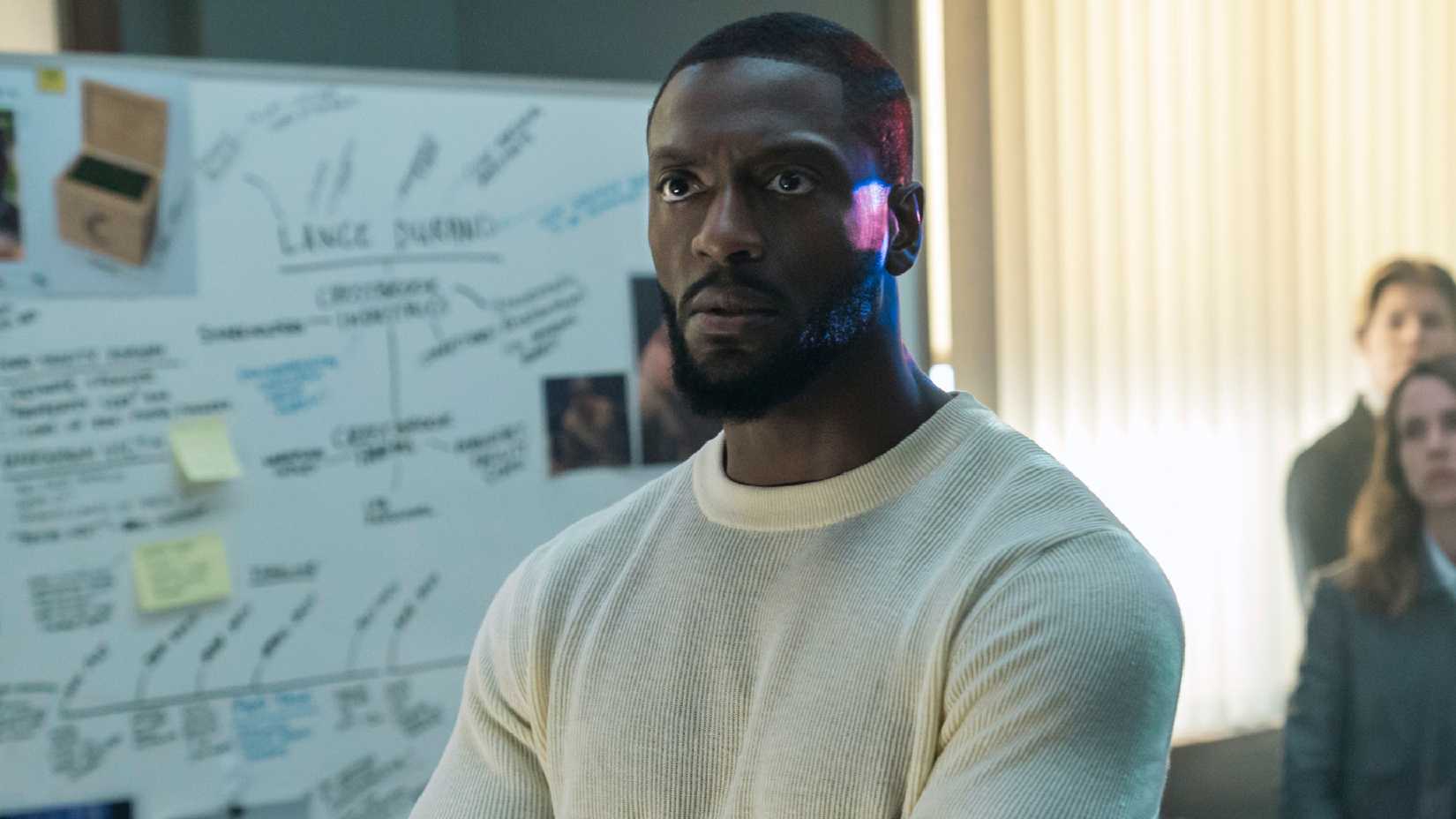 Alex Cross está de pie frente a una pizarra de crímenes en la oficina en la temporada 2 de Cross.