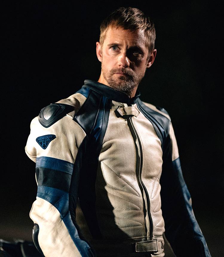 Alexander Skarsgård como Ray, encostado em sua moto em Pillion.
