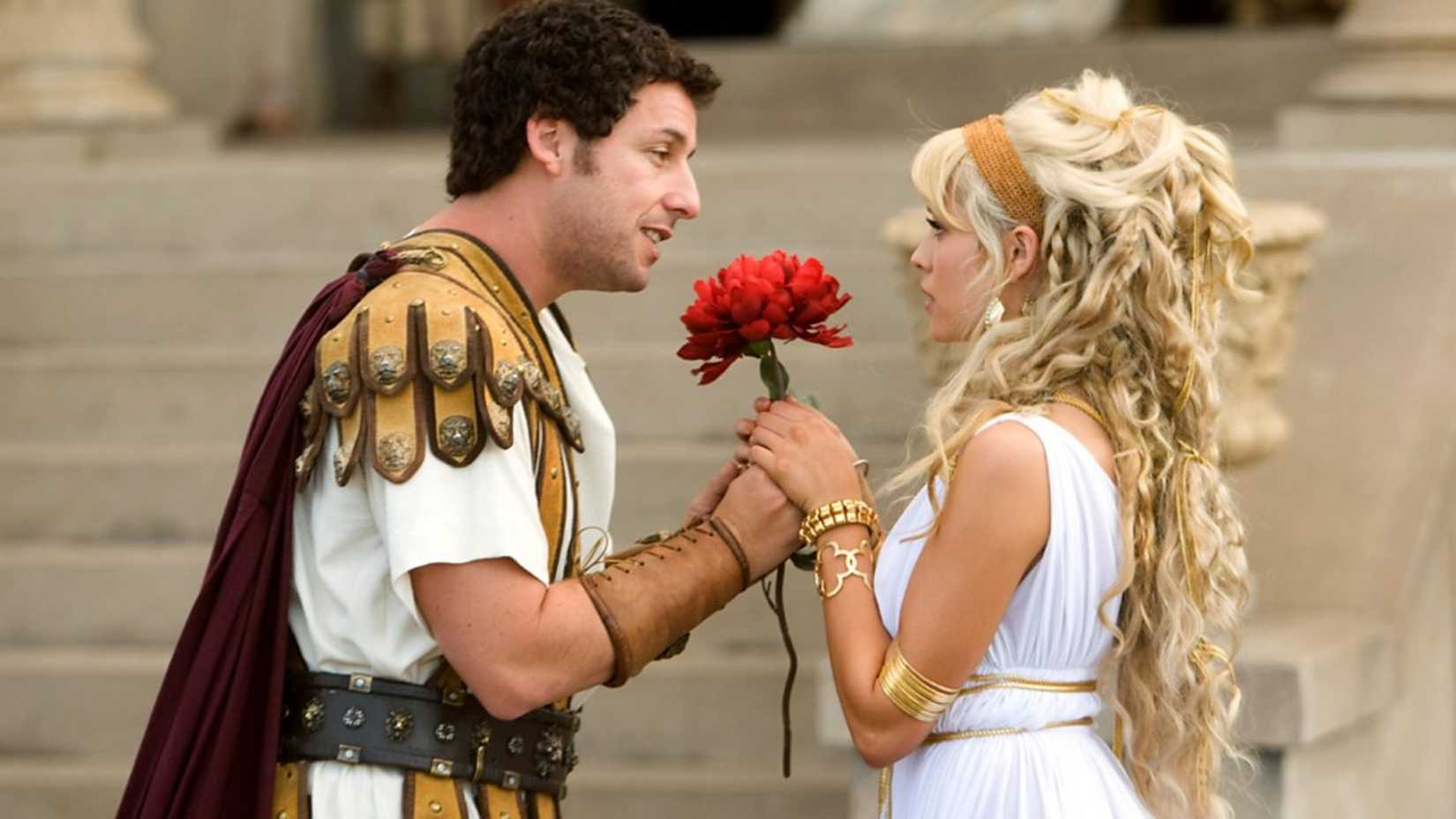 Адам Сандлер протягивает женщине цветок, одетый в древнеримскую одежду, в фильме "Bedtime Stories"