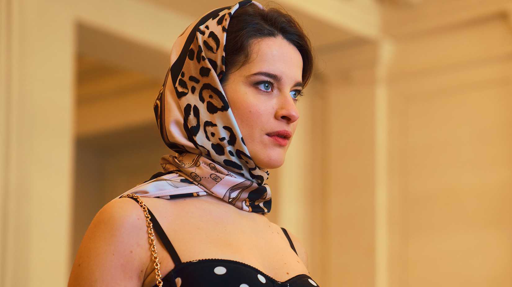 Ein Bild einer Frau, die ein Kopftuch trägt und in Cash Queens nach vorne blickt