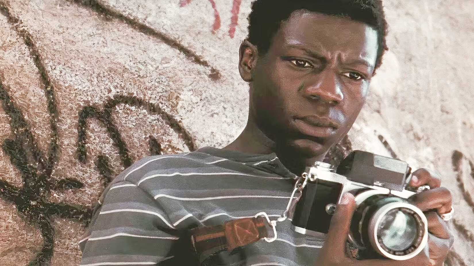Character from City of God holding a camera