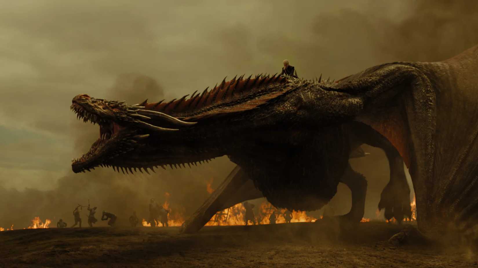 Daenerys on the back of Drogon on a firey battlefield in Game of Thrones