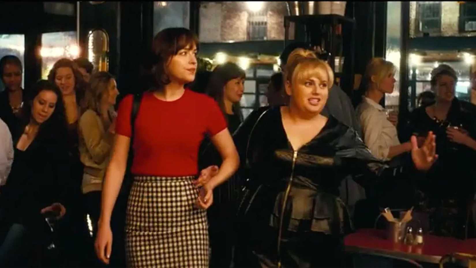 Dakota Johnson como Alice Kepley em um bar com Rebel Wilson como Robin em Como Ser Solteira