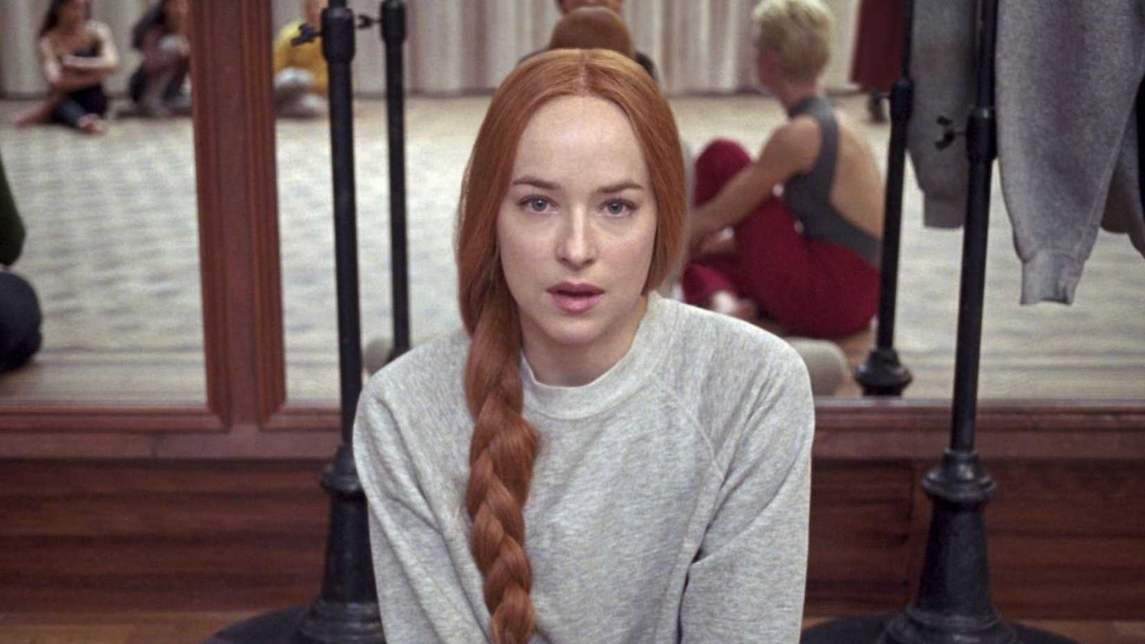 Dakota Johnson como Susie Bannion sentada no chão em Suspiria