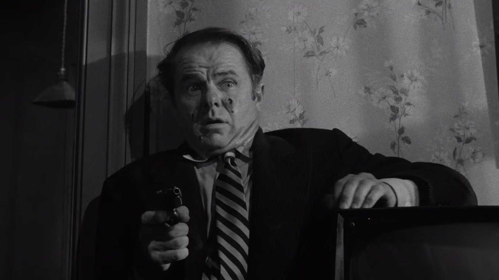Elisha Cook Jr stunned and pointing a gun in Stanley Kubrick's The Killing