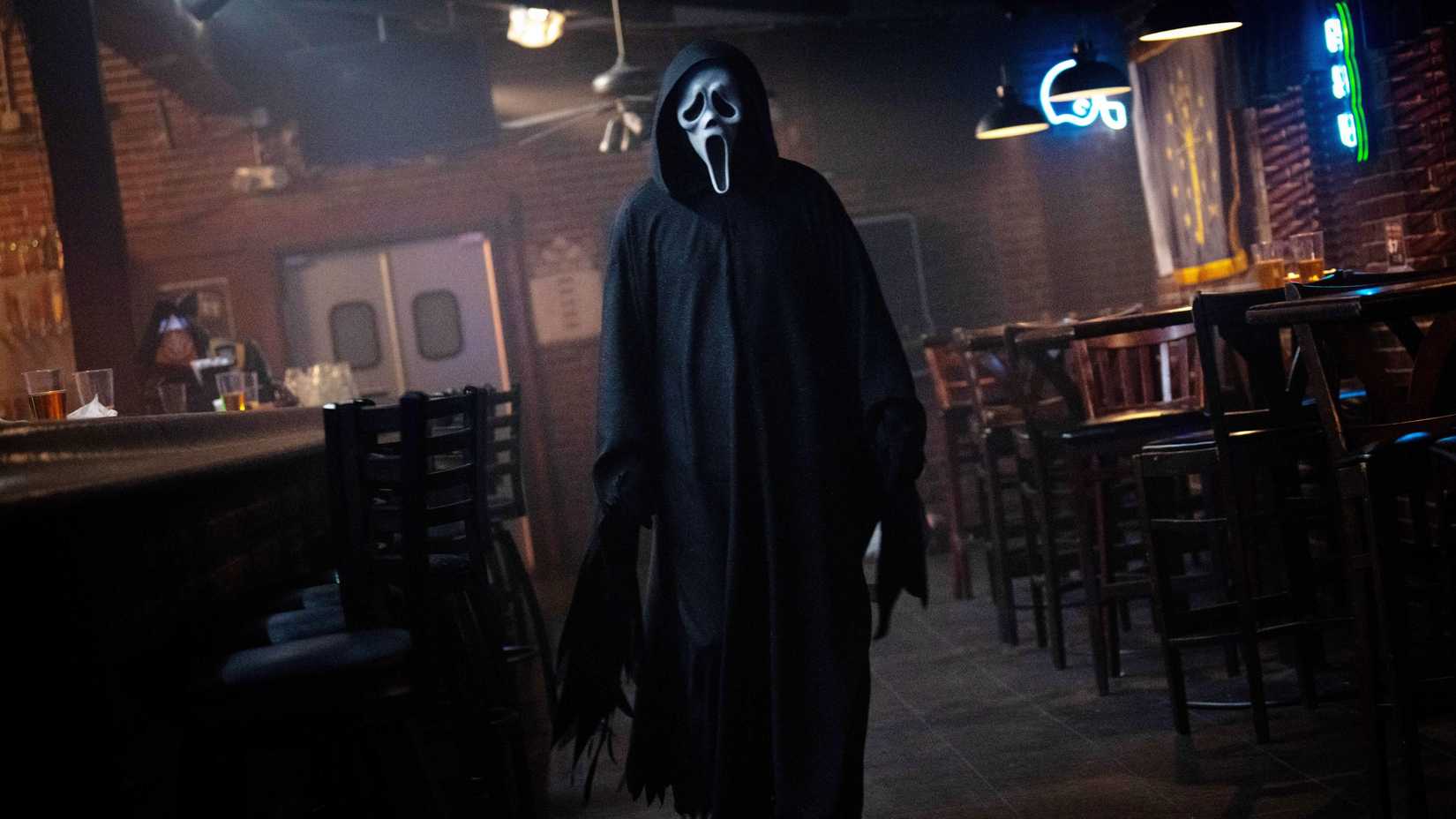 Ghostface caminhando em bar vazio em Scream 7