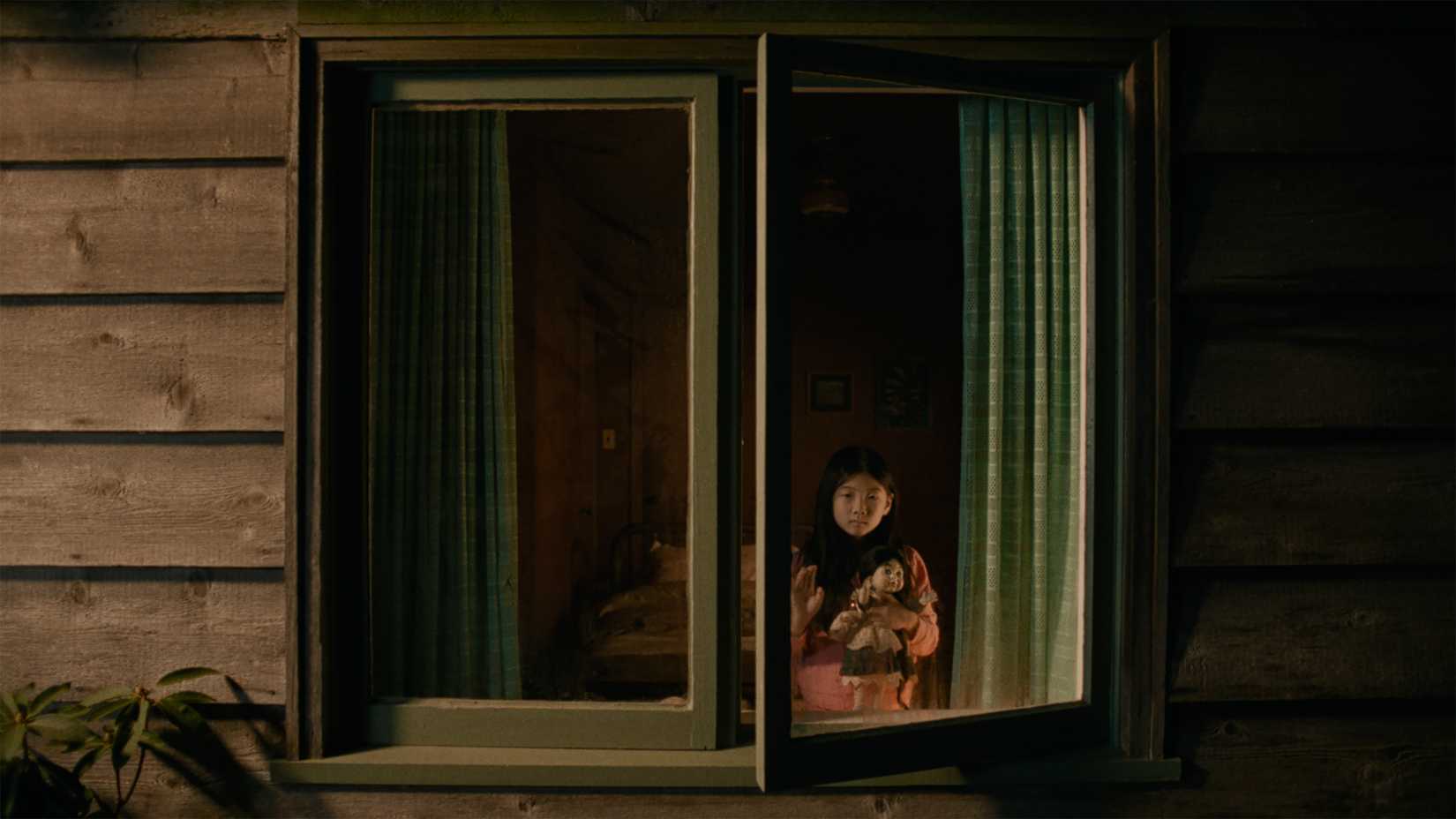 Gracie schaut aus ihrem Fenster, während sie in Rock Springs eine Puppe in der Hand hält