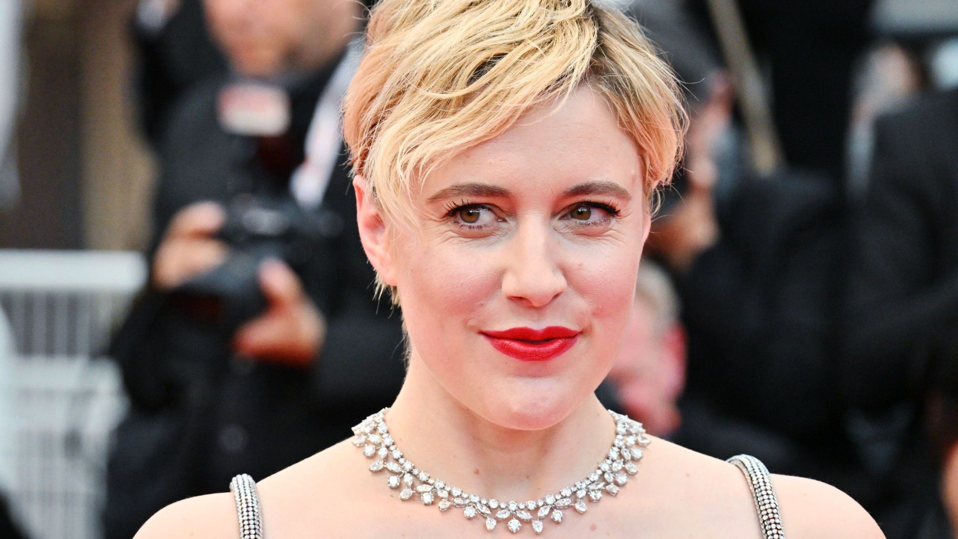 Greta Gerwig sorri no tapete vermelho