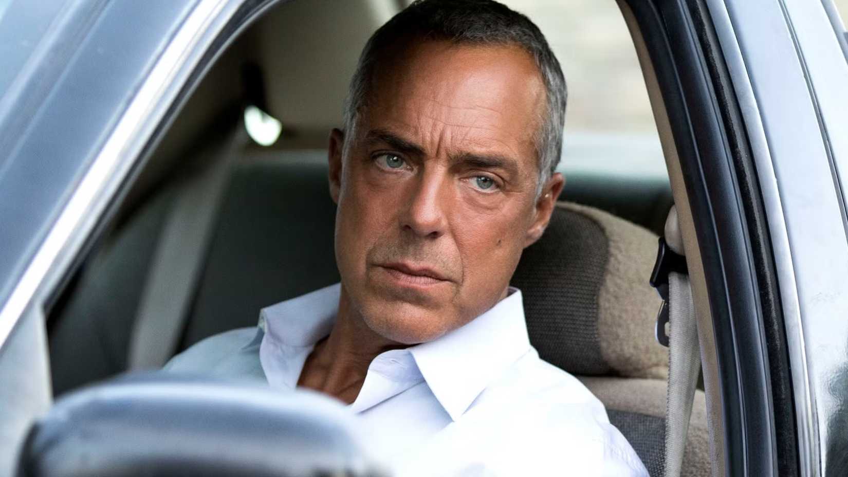 Harry Bosch (Titus Welliver) no carro olhando pela janela com seriedade em Bosch